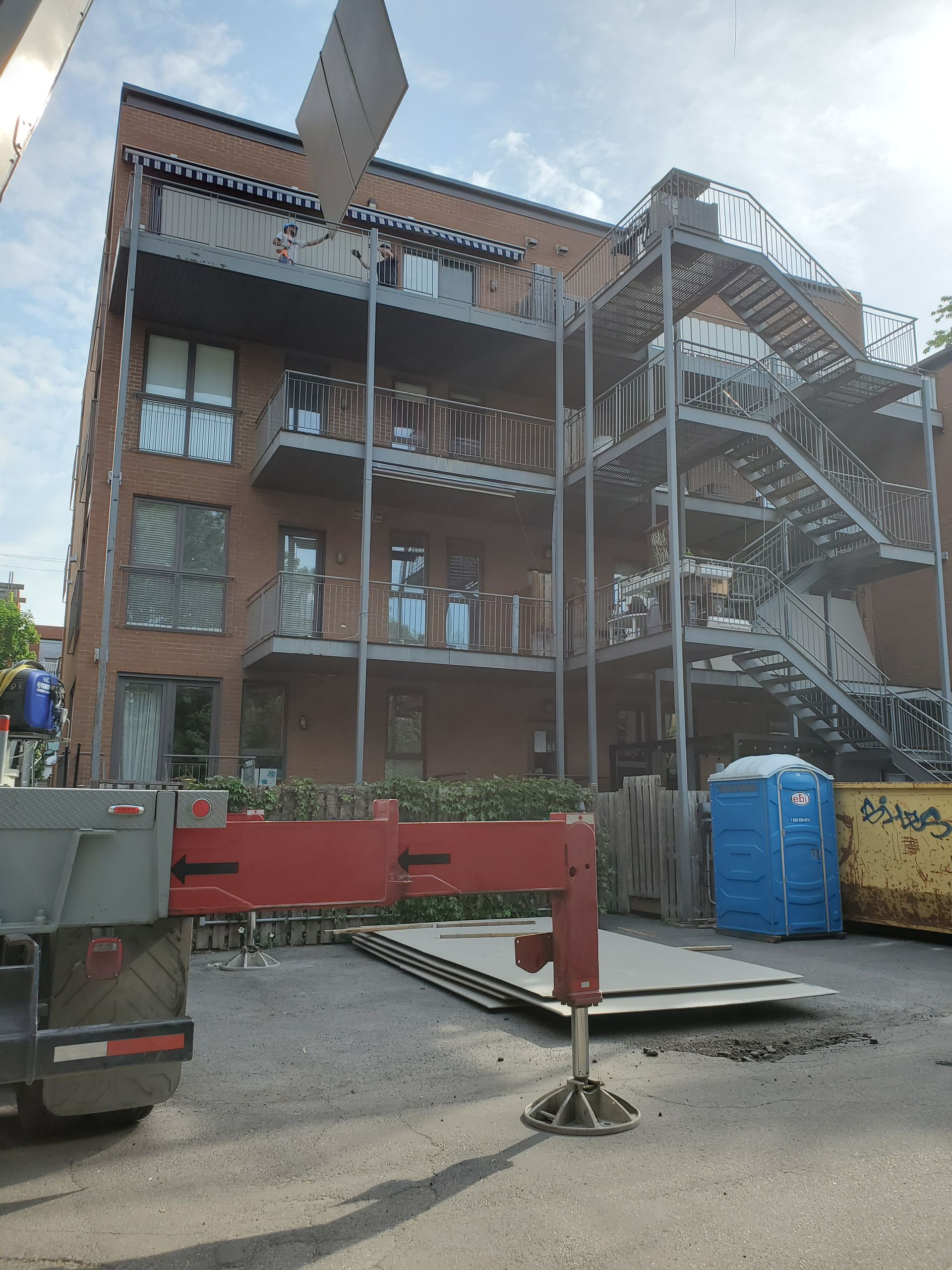 Un grand bâtiment en brique avec des escaliers et une grue devant
