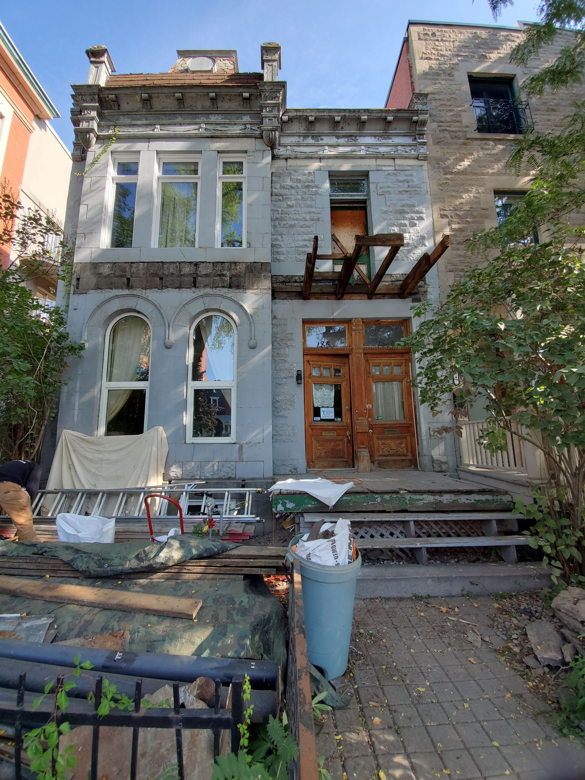 Un grand bâtiment en brique avec une poubelle devant