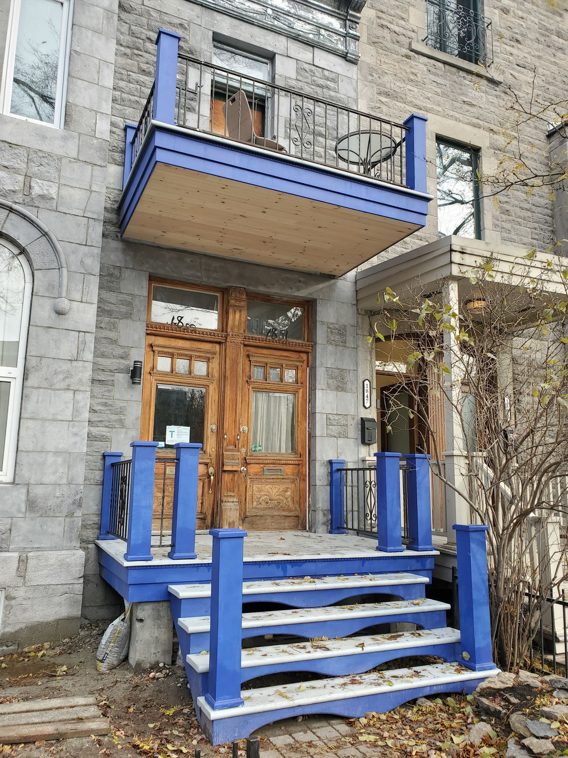 La façade d'un immeuble en brique avec des escaliers bleus et un balcon.