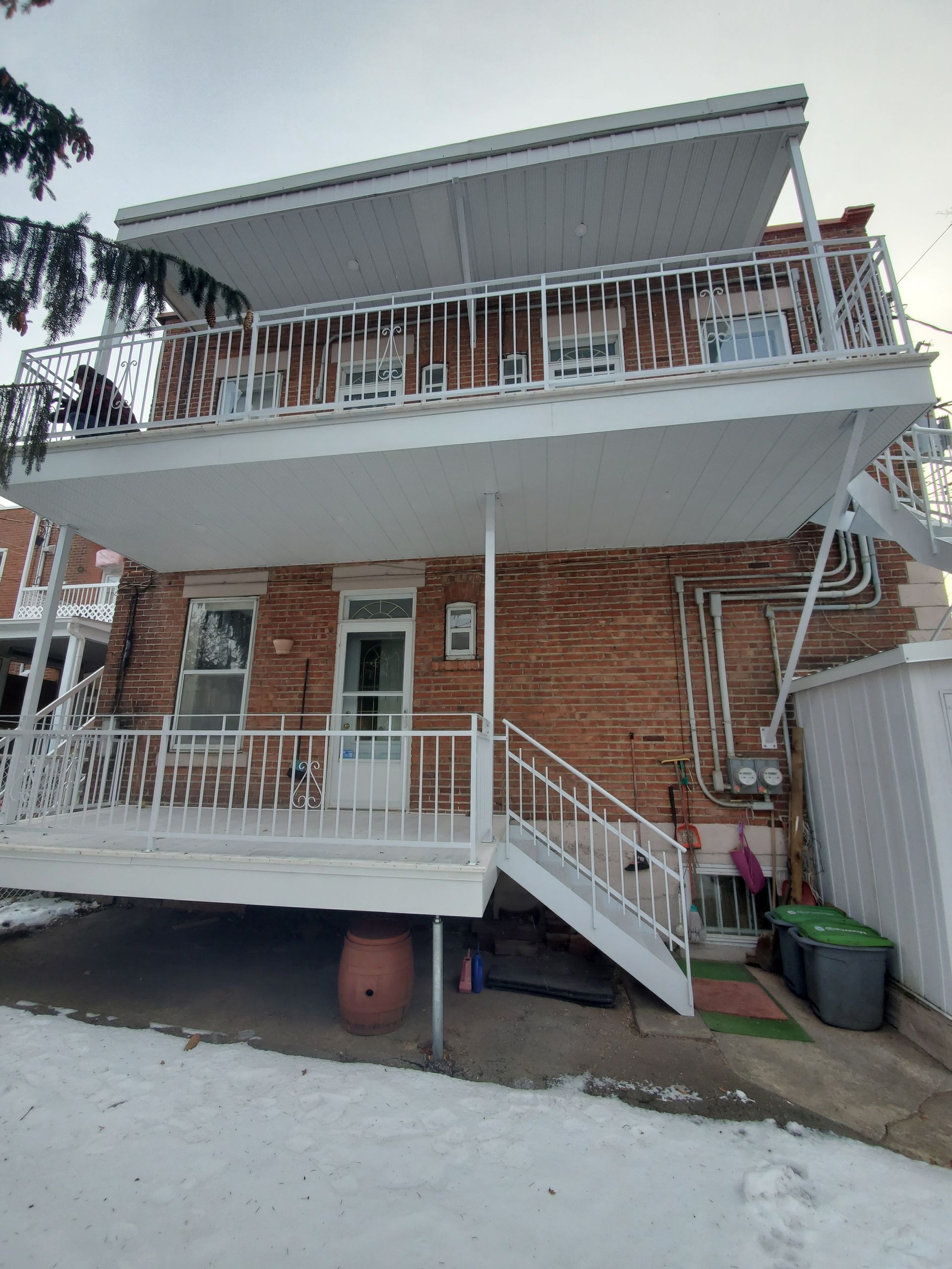 L'arrière d'une maison en brique avec balcon et escaliers.