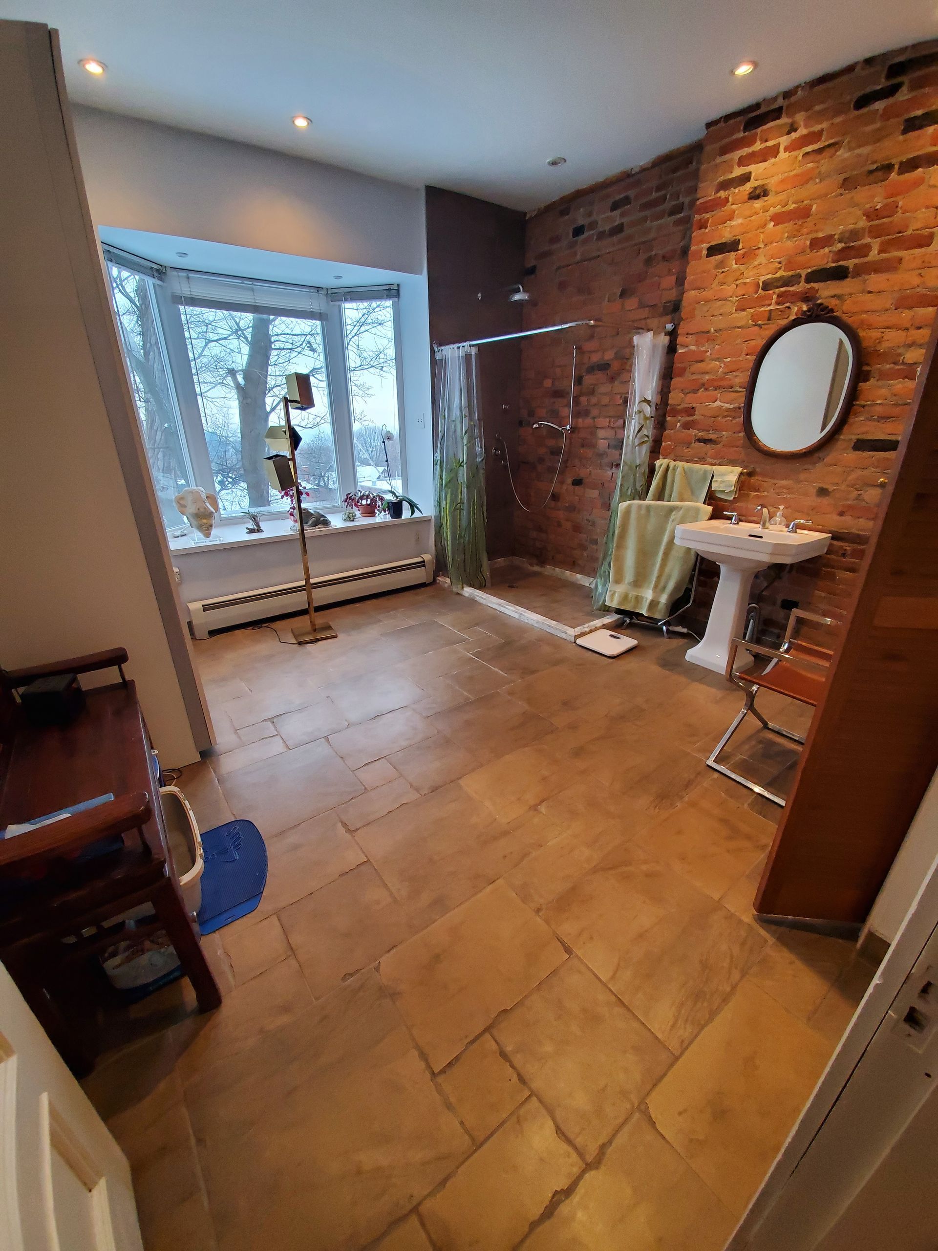 Une salle de bain avec lavabo, miroir et douche à l'italienne.
