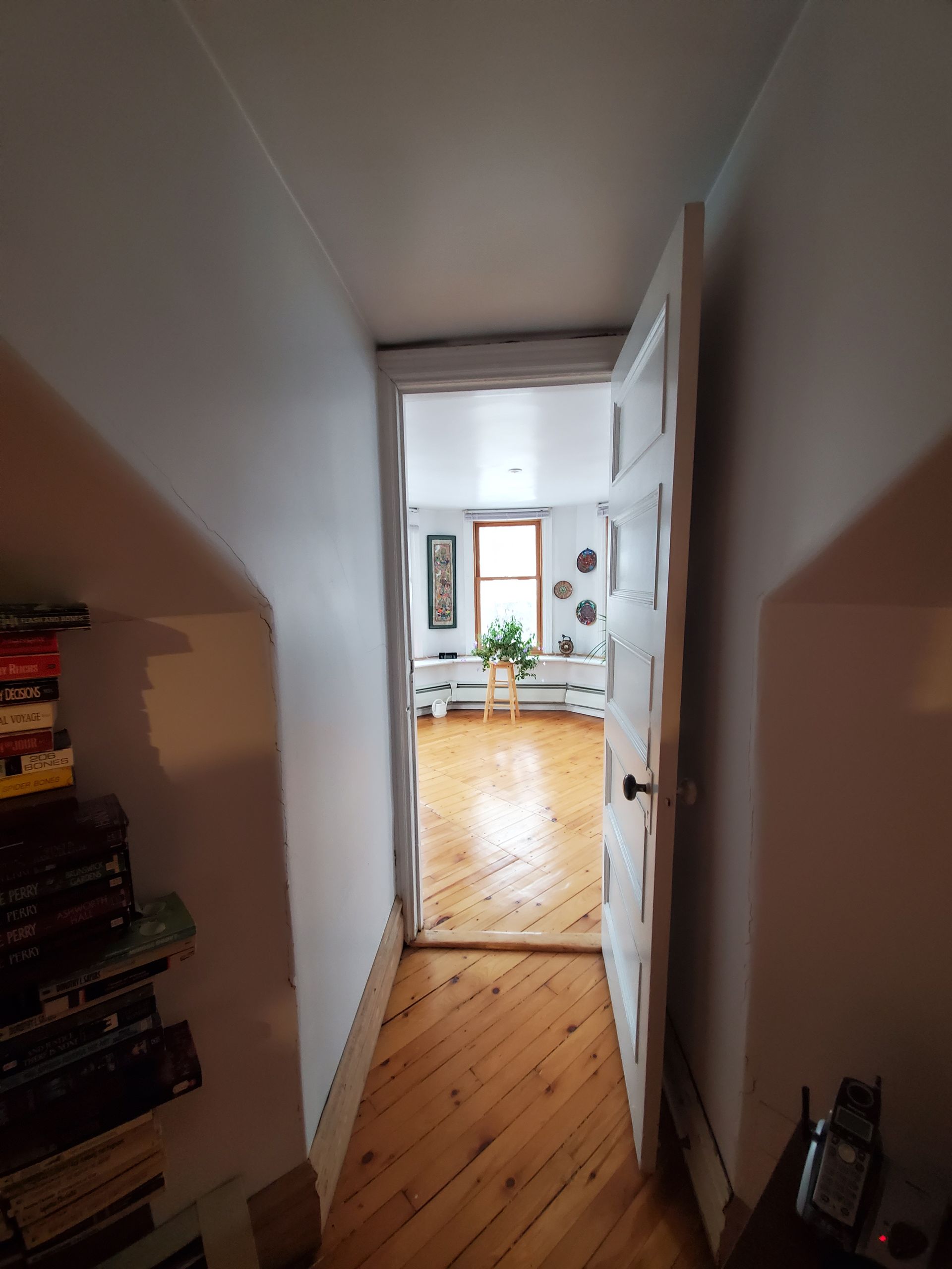Un couloir menant à un séjour avec parquet au sol