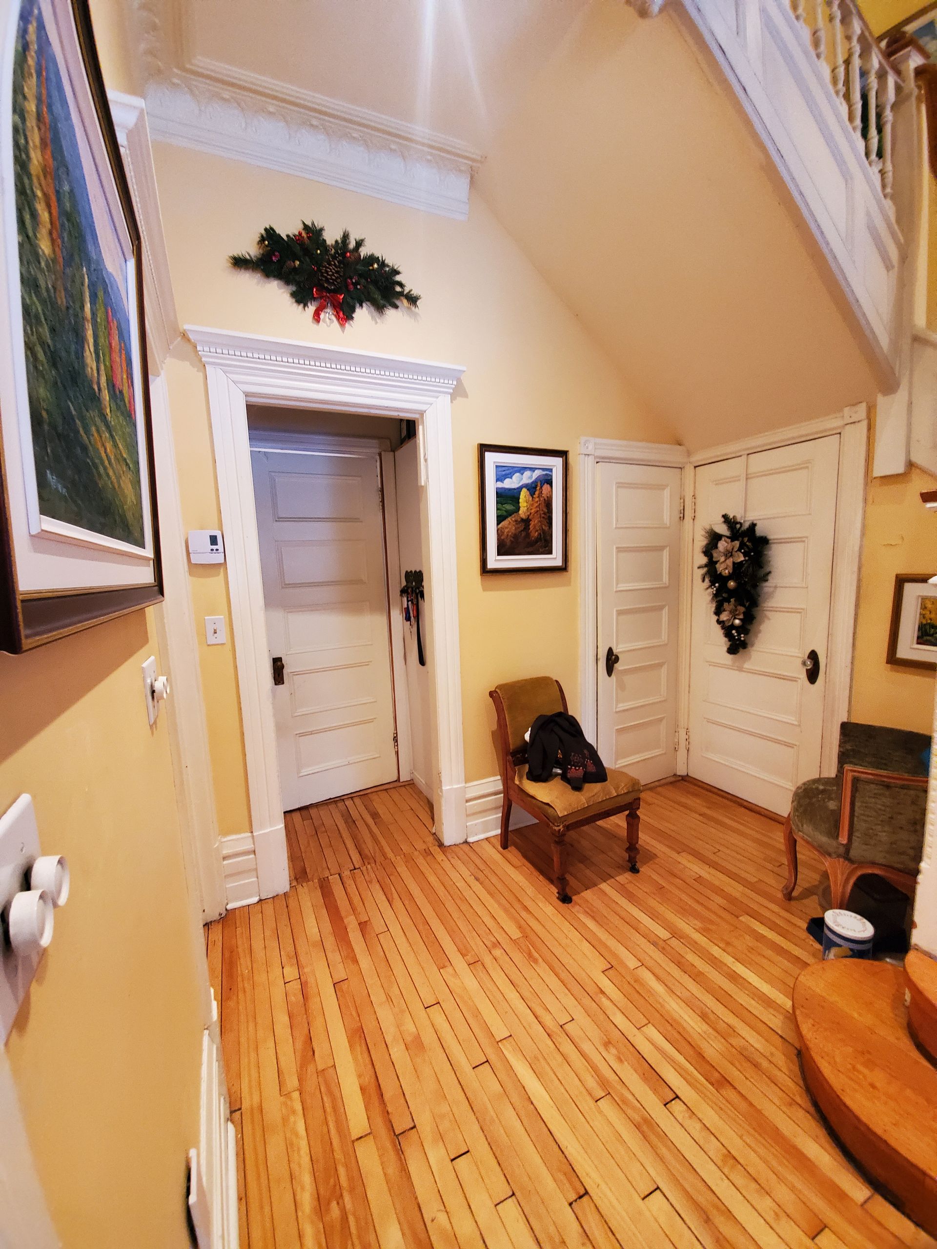 Un couloir avec parquet et tableau au mur