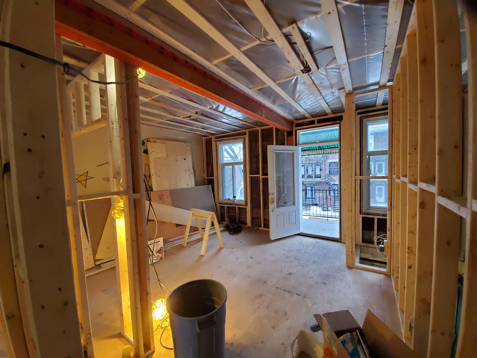 Une pièce en construction avec des poutres en bois et une porte.