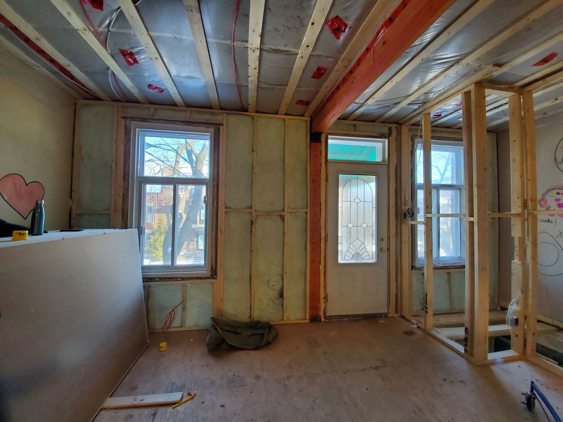 Une pièce en cours de rénovation avec un cœur sur le mur.