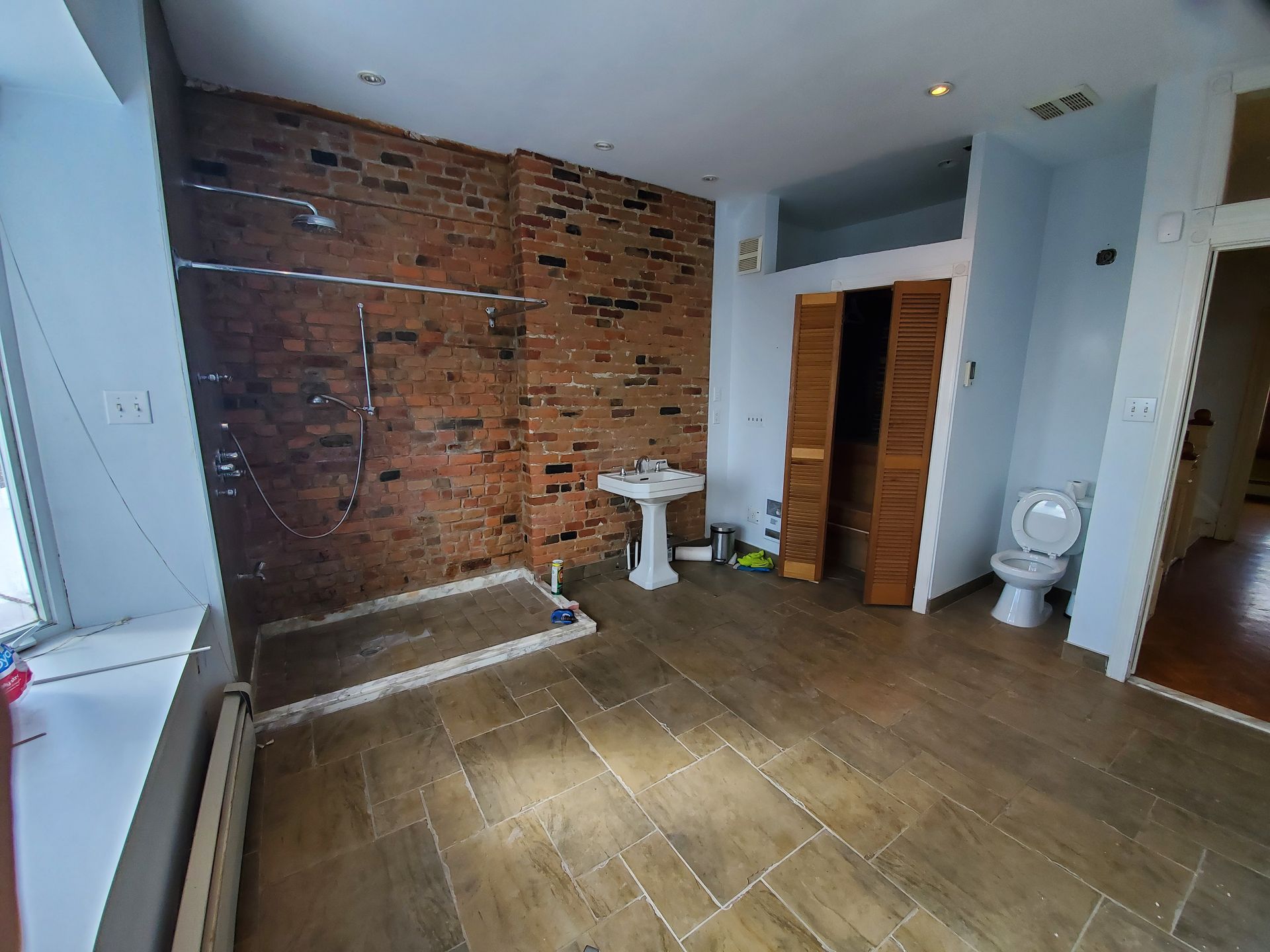 Une salle d'eau avec douche à l'italienne, lavabo et toilettes.