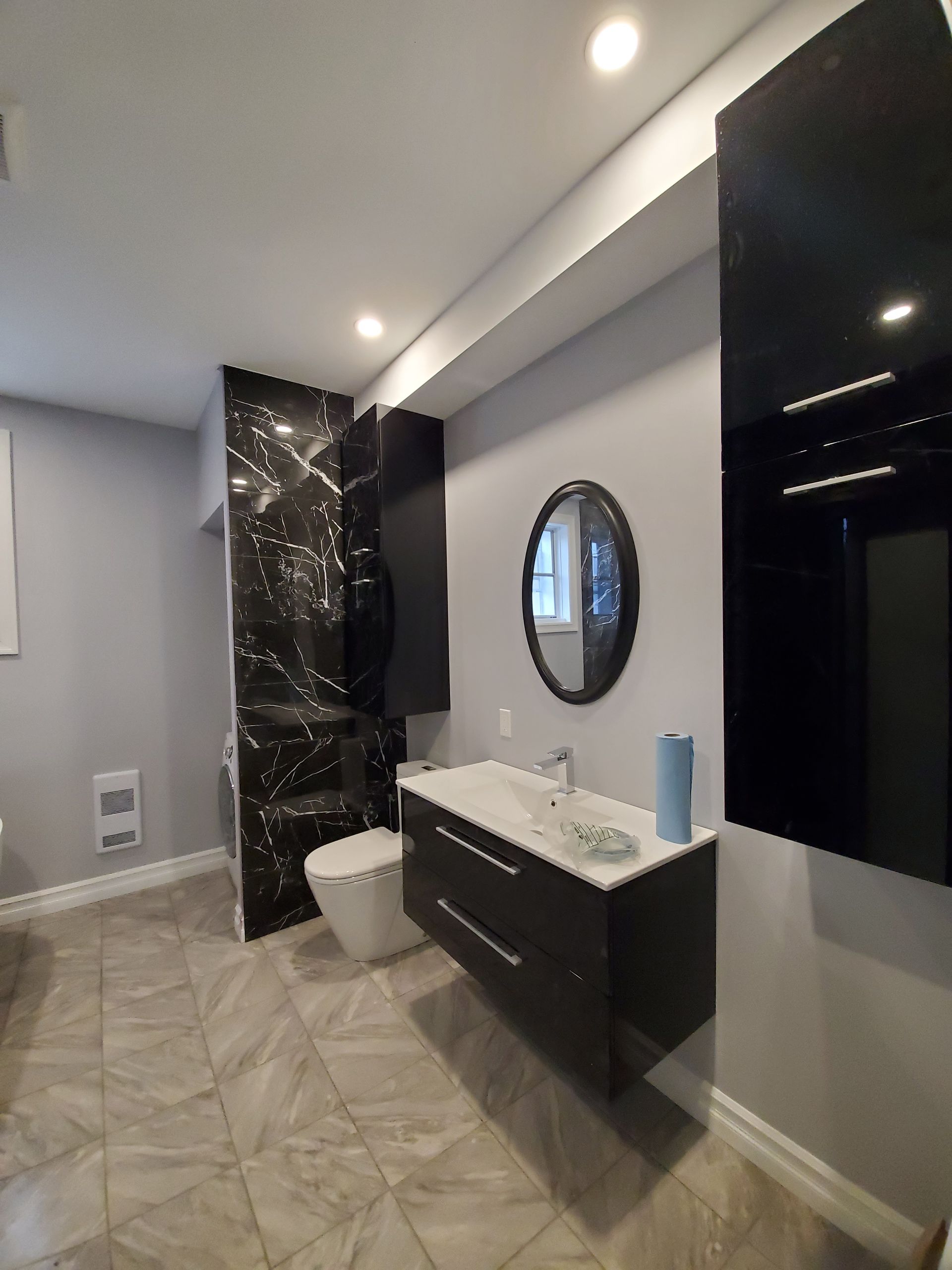 Une salle de bain avec lavabo, toilettes et miroir.