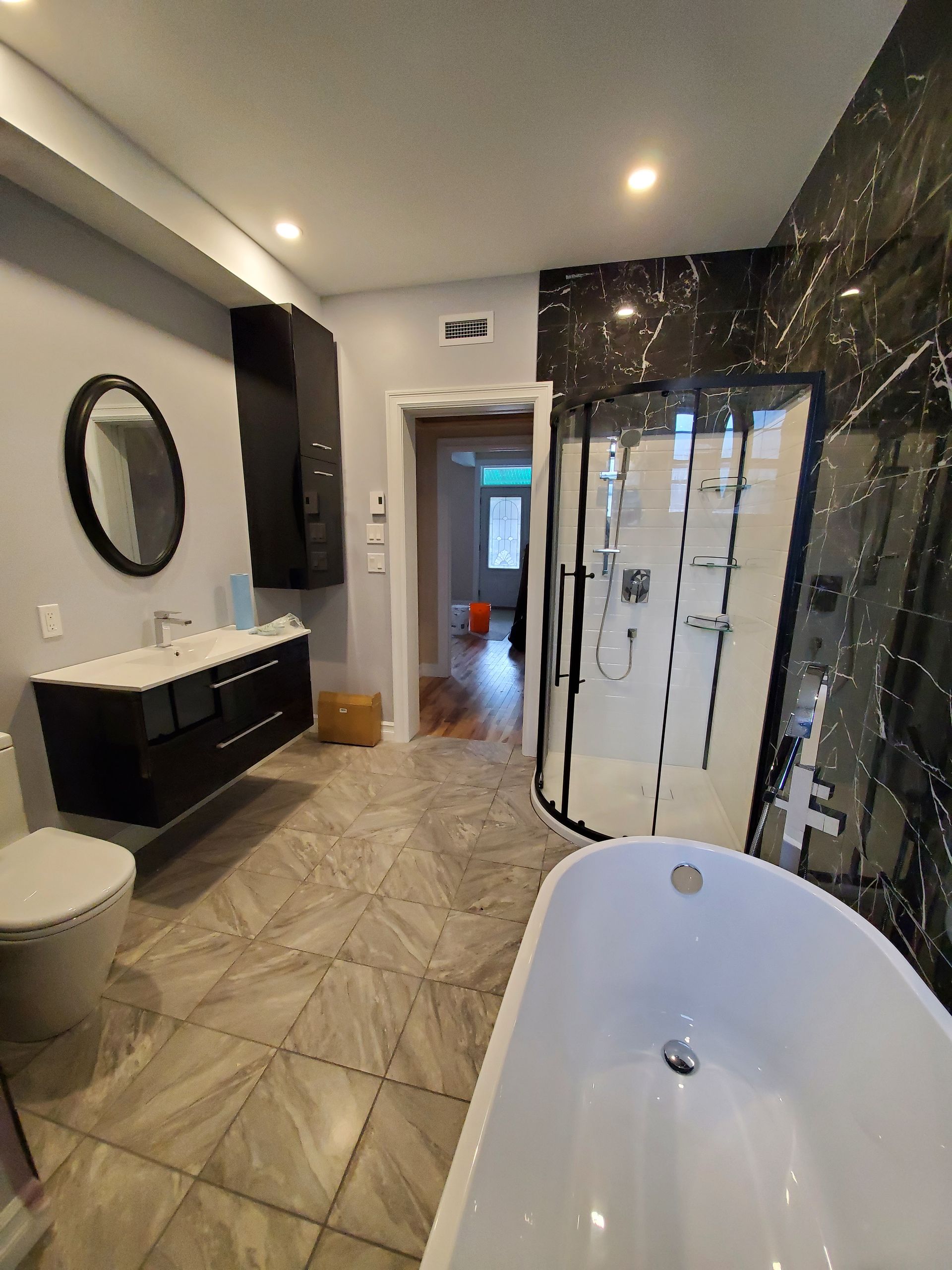 Une salle de bain avec baignoire , WC , lavabo et douche.