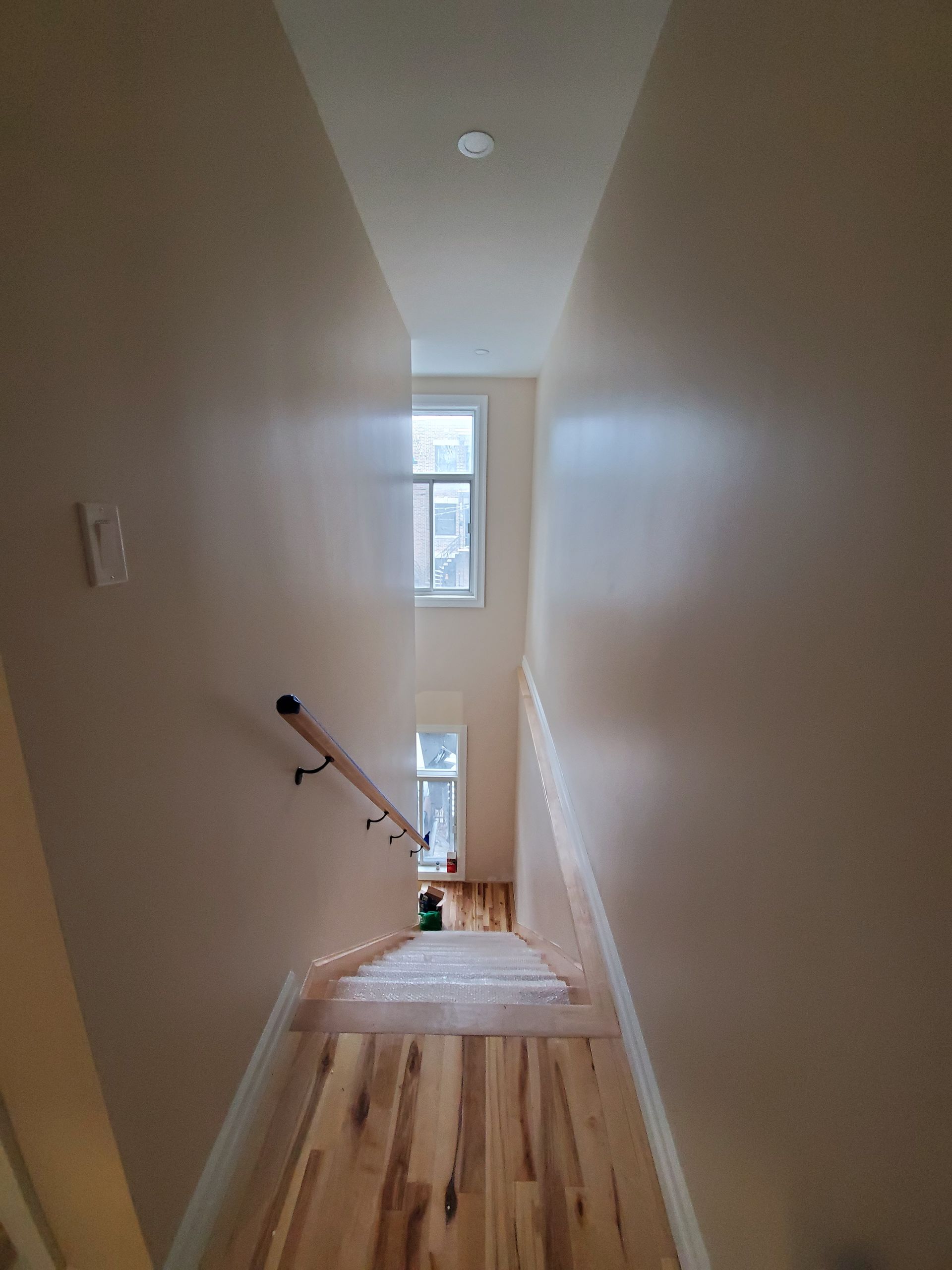 Un couloir avec des escaliers menant au deuxième étage d'une maison.