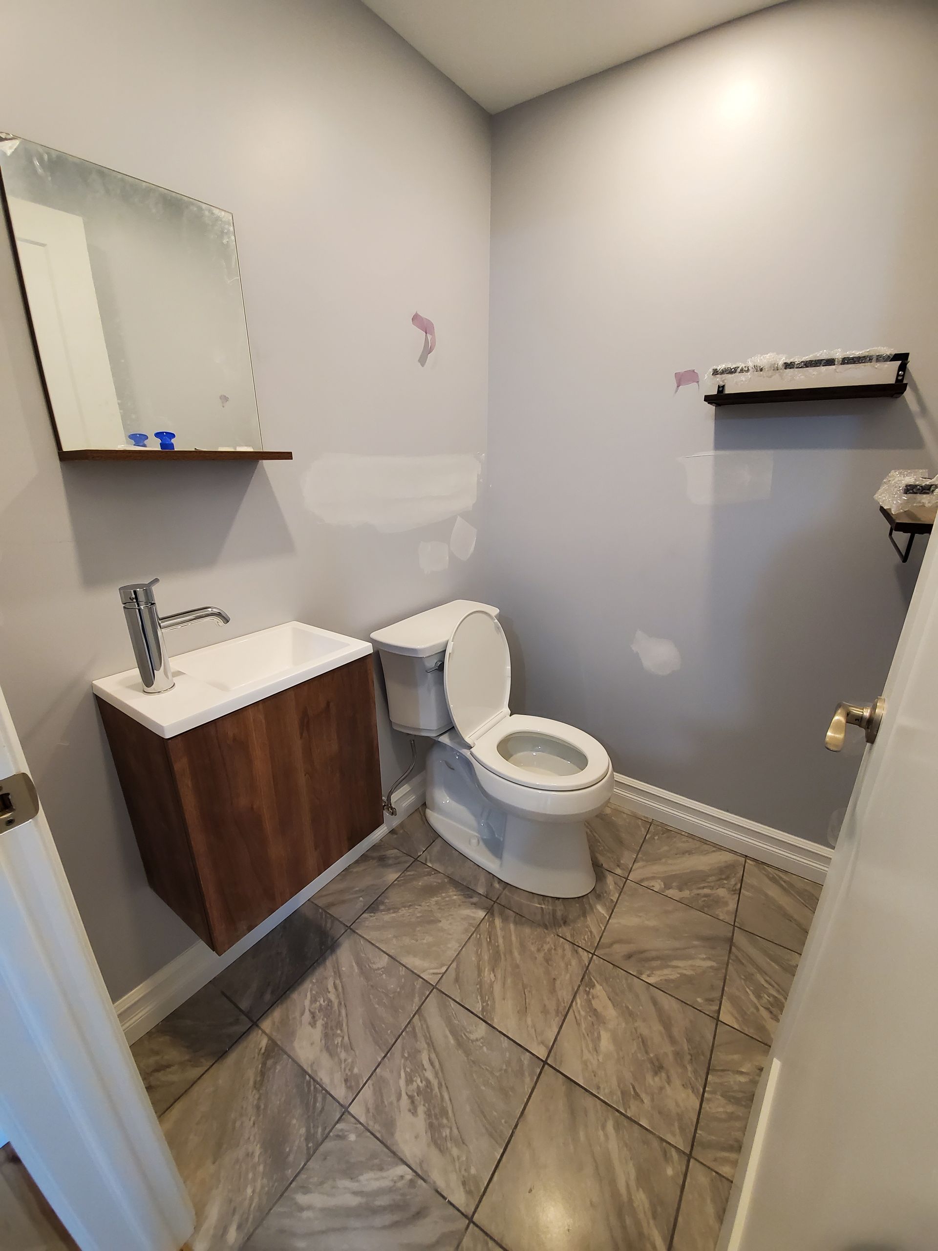 Une salle de bain avec WC , lavabo et miroir.
