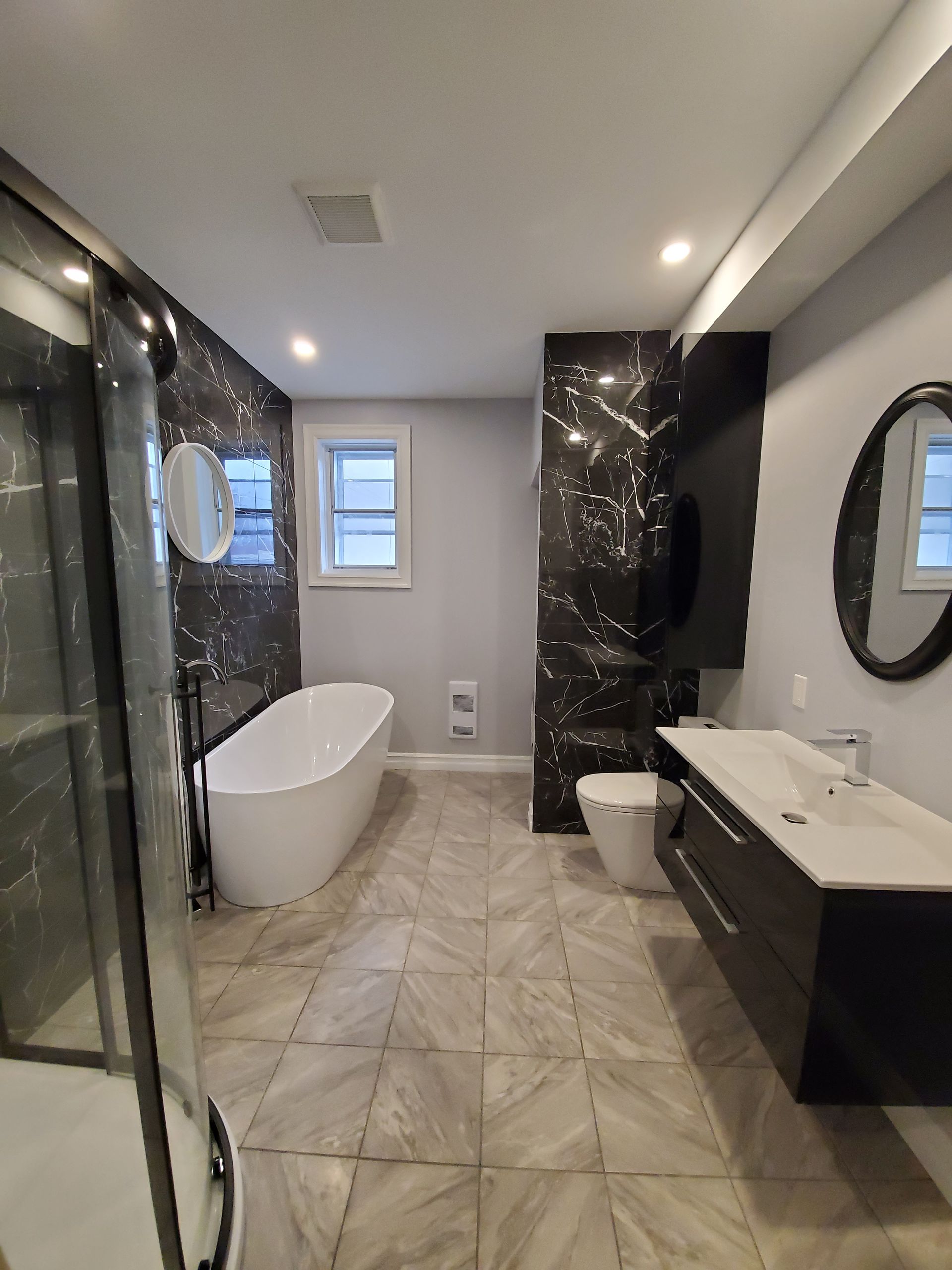 Une salle de bain avec baignoire , lavabo , toilettes et miroir.