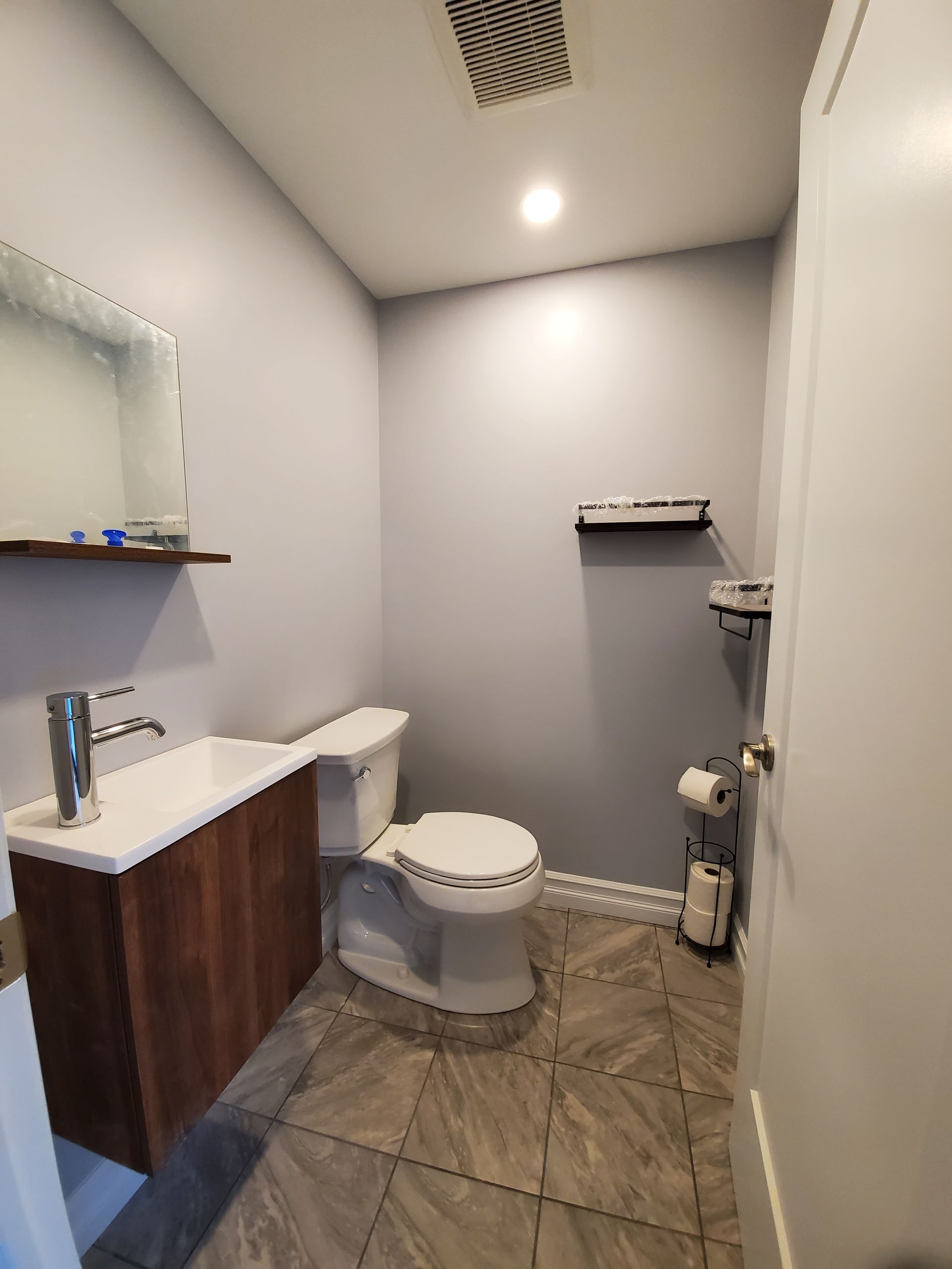 Une salle de bain avec WC , lavabo et miroir.