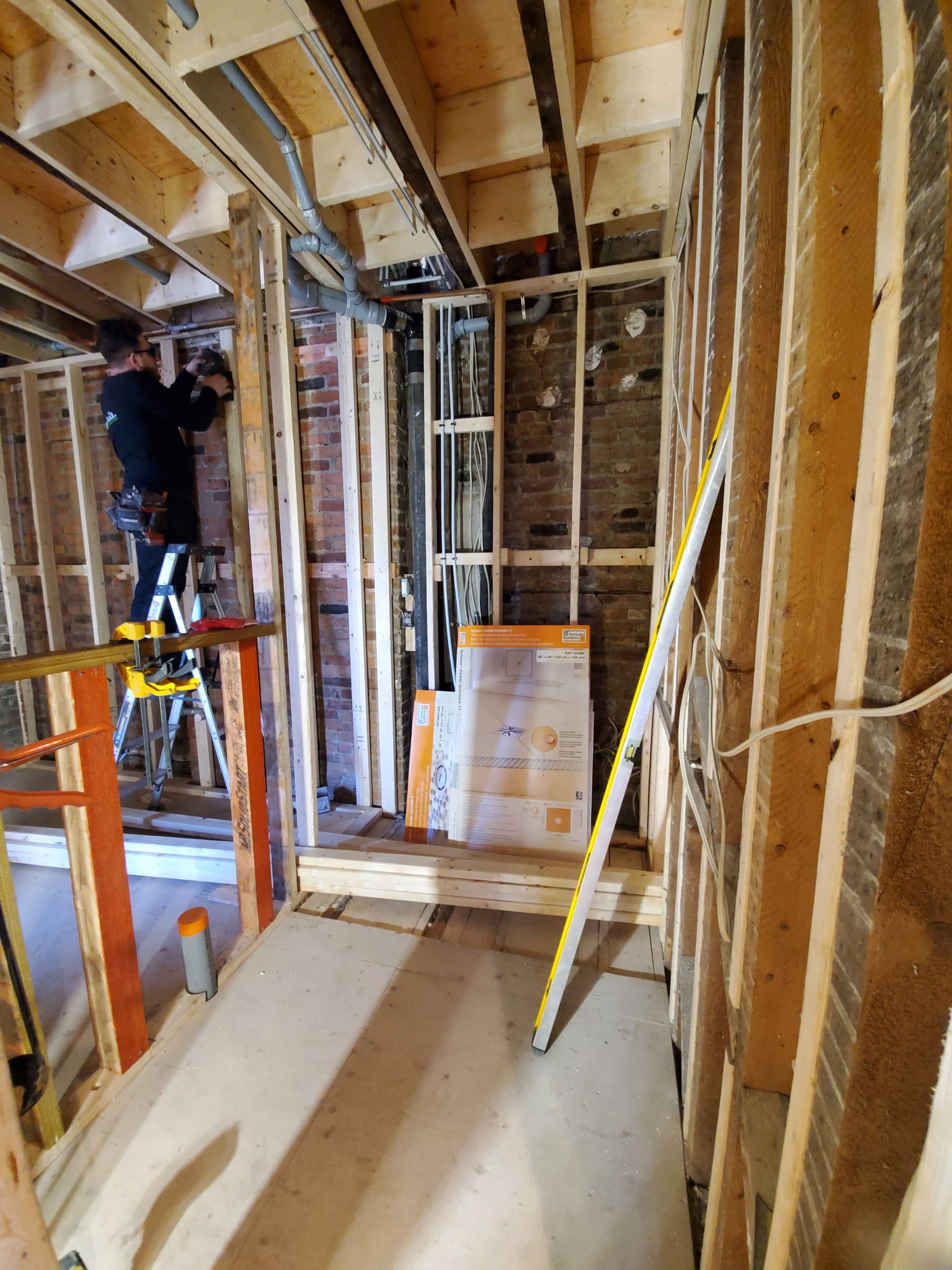 Un homme est debout sur une échelle dans une pièce en construction.