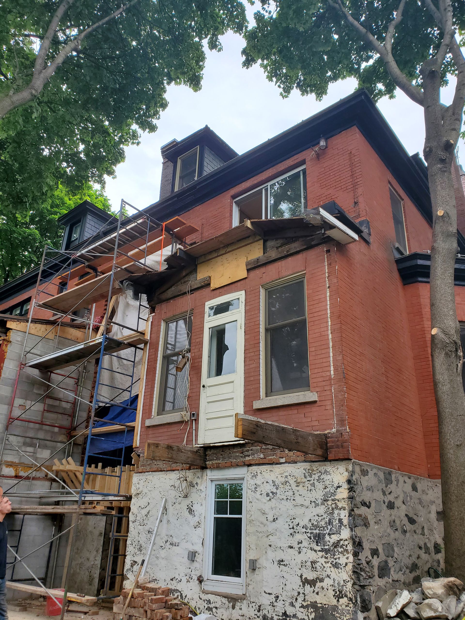 Un grand bâtiment en briques rouges est en cours de rénovation.