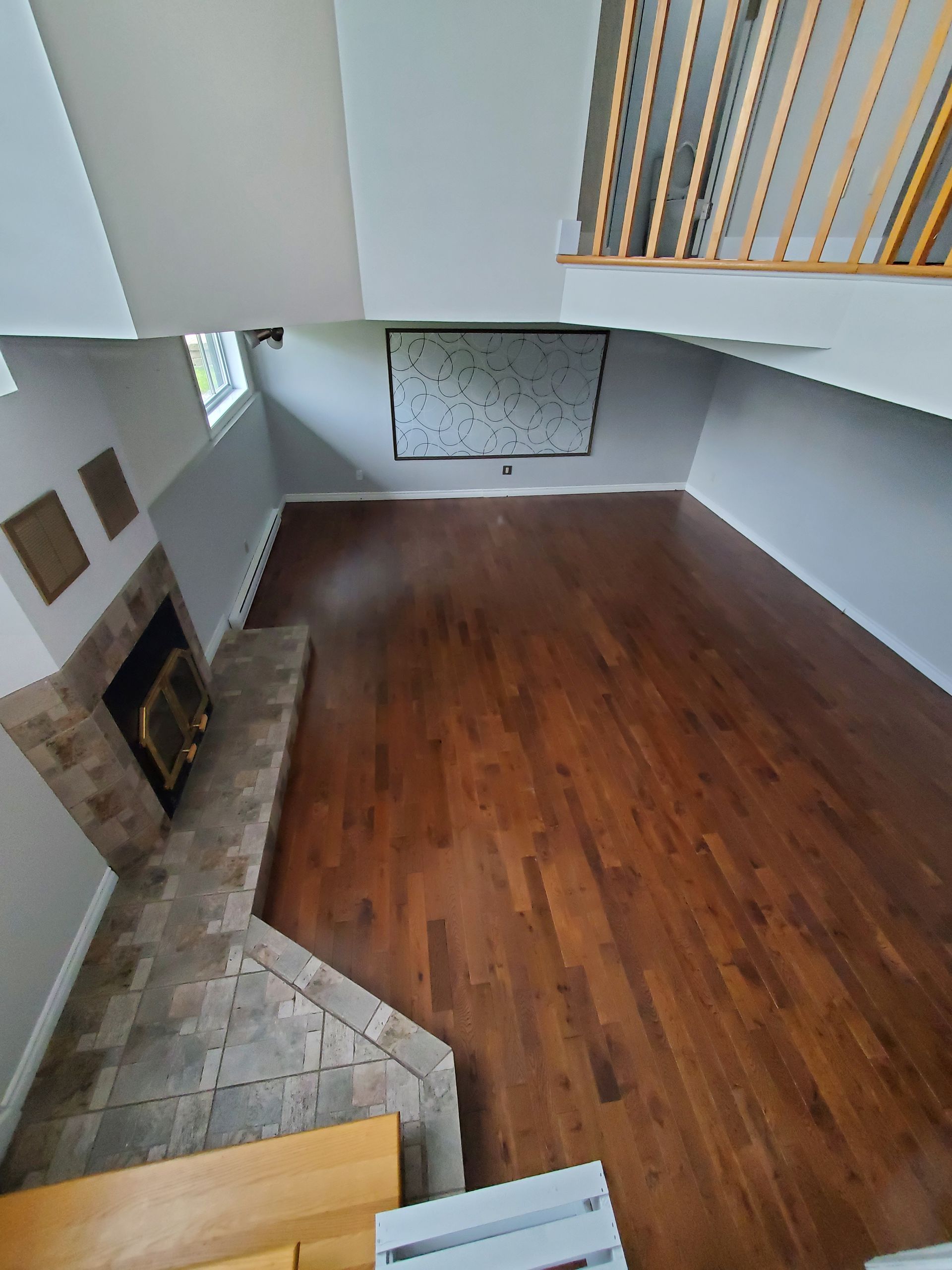 Un salon avec parquet et cheminée.