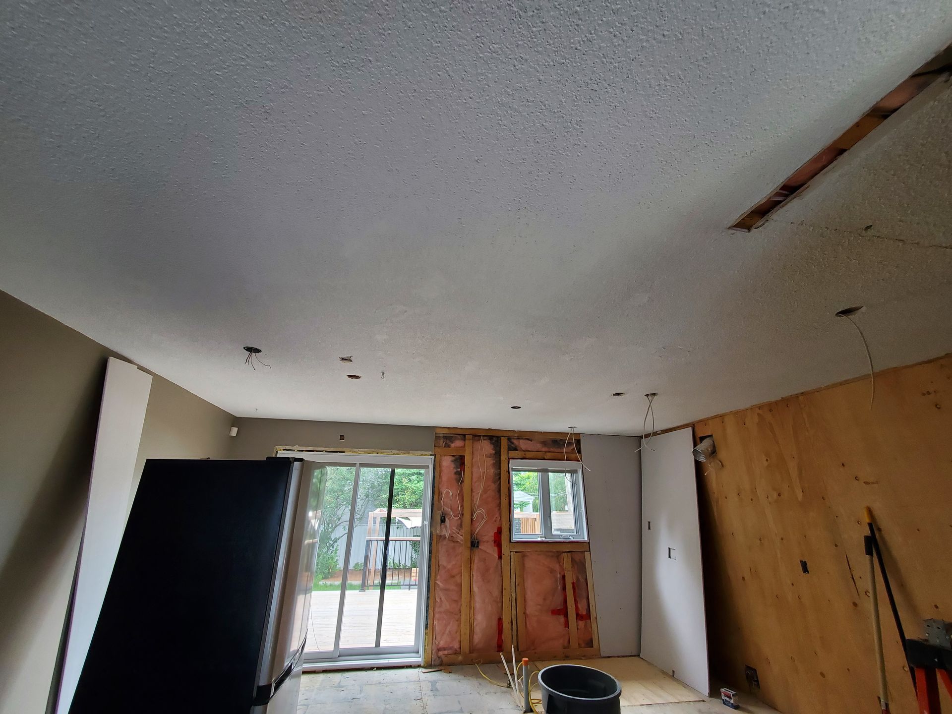 Une pièce avec un plafond blanc et des murs en bois est en cours de rénovation.