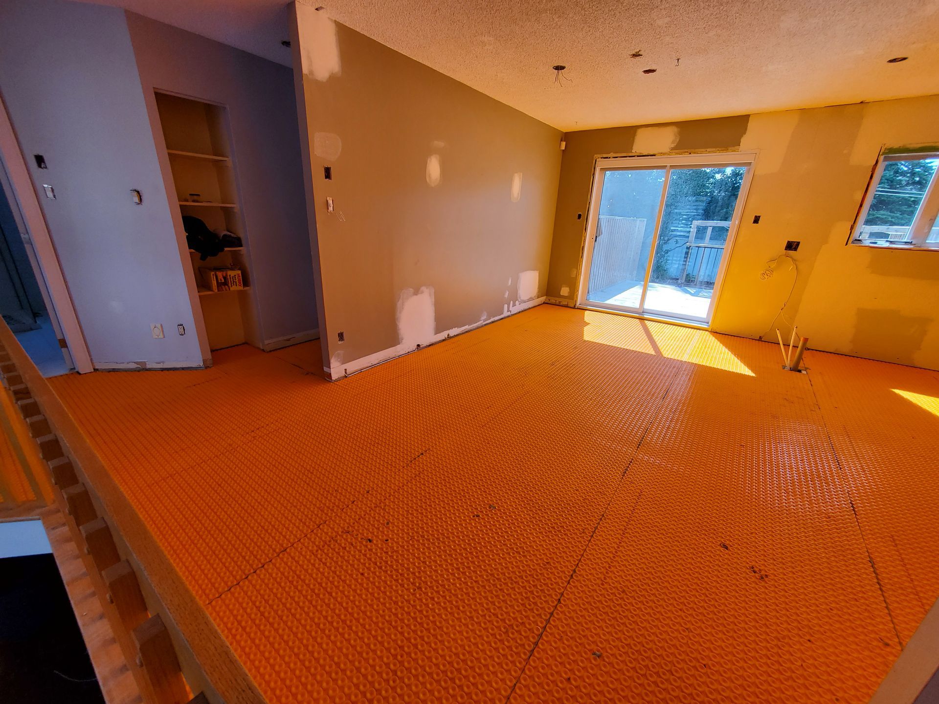 Un salon avec une porte vitrée coulissante et un grand sol orange.