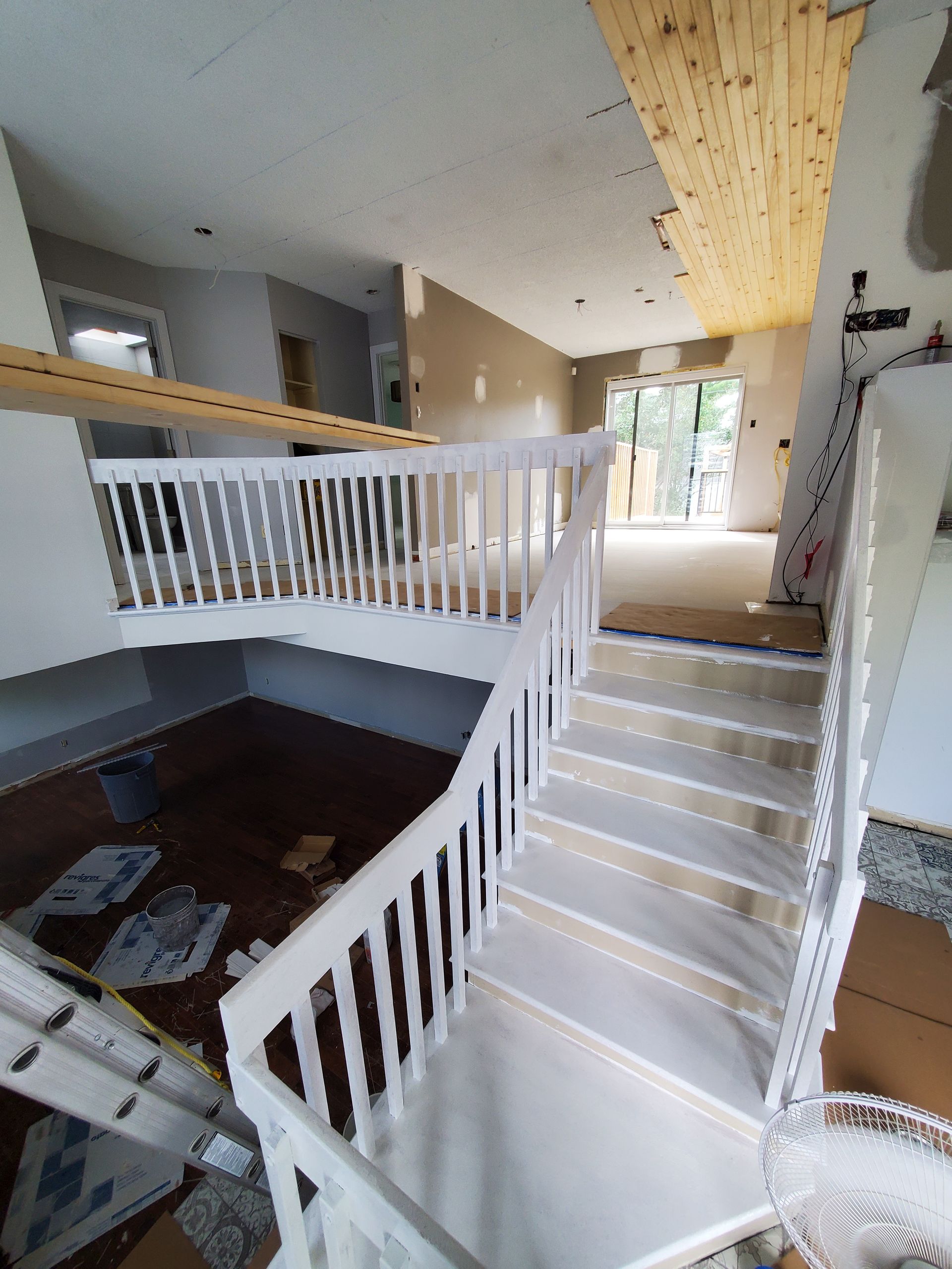 Un escalier blanc dans une maison avec une balustrade en bois