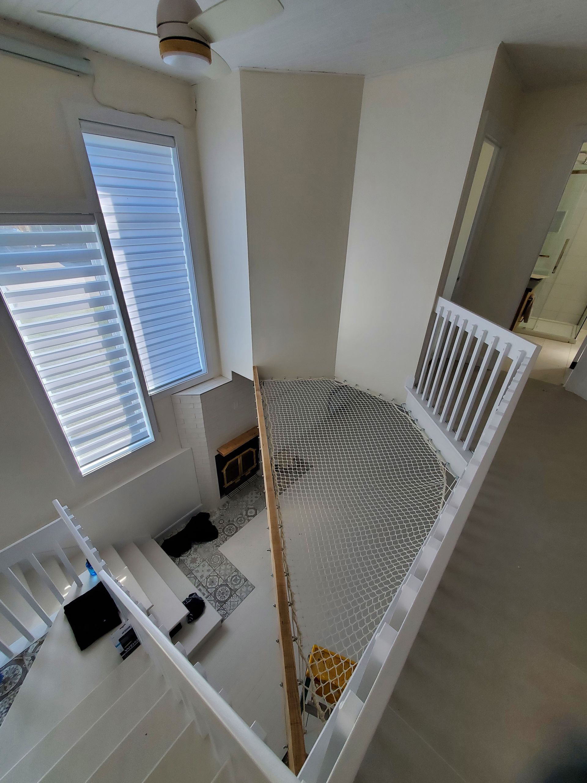 Une vue aérienne d'un escalier dans une maison avec un ventilateur de plafond.