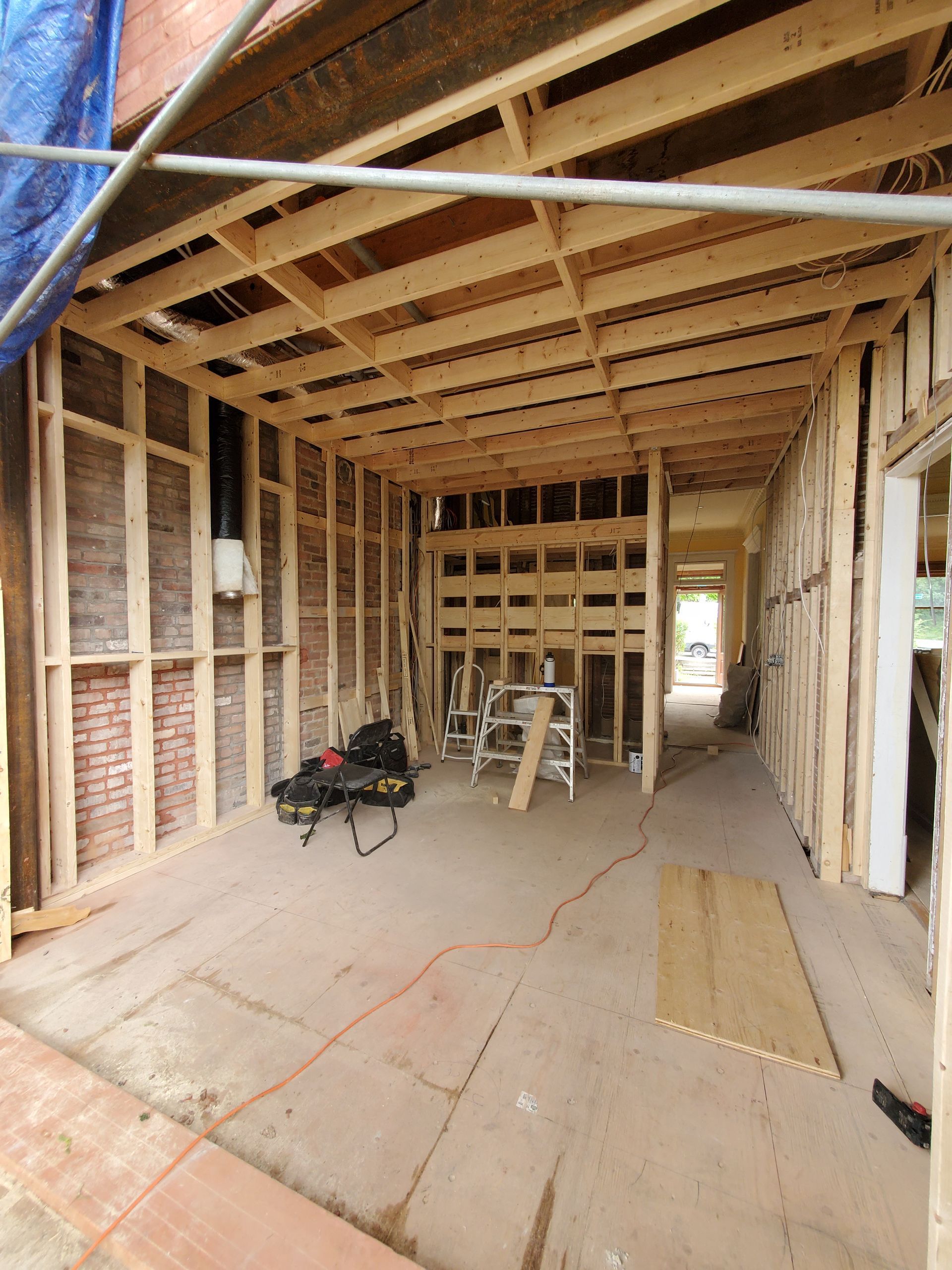 Une pièce en construction avec poutres en bois et murs en briques.