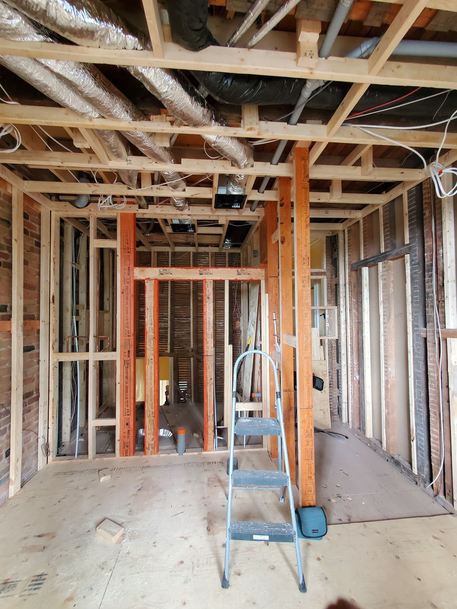 Une échelle est posée au milieu d'une pièce en construction.
