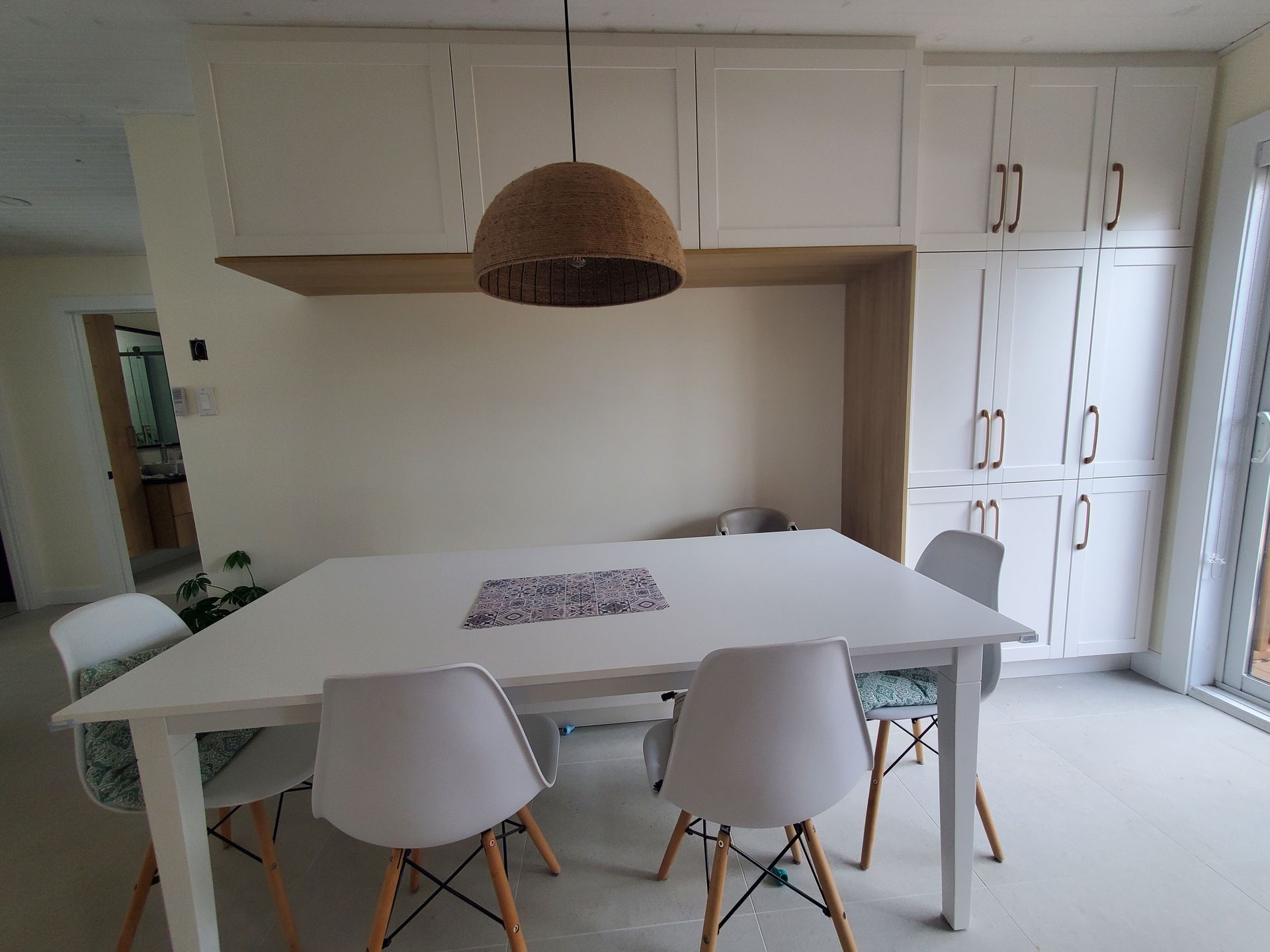 Une salle à manger avec une table et des chaises et une lampe suspendue au plafond.