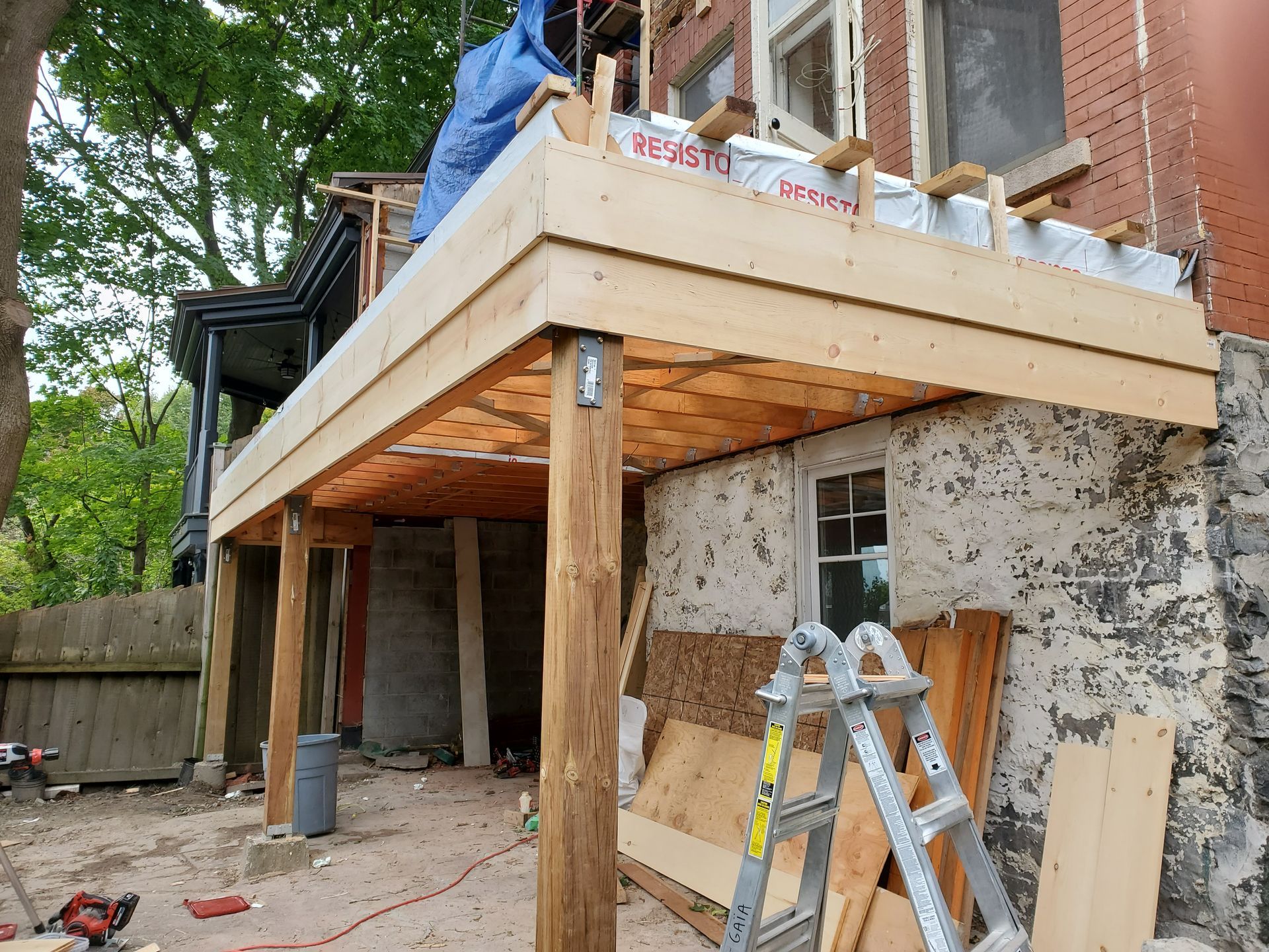 Une terrasse en bois est en cours de construction sur le côté d'une maison.