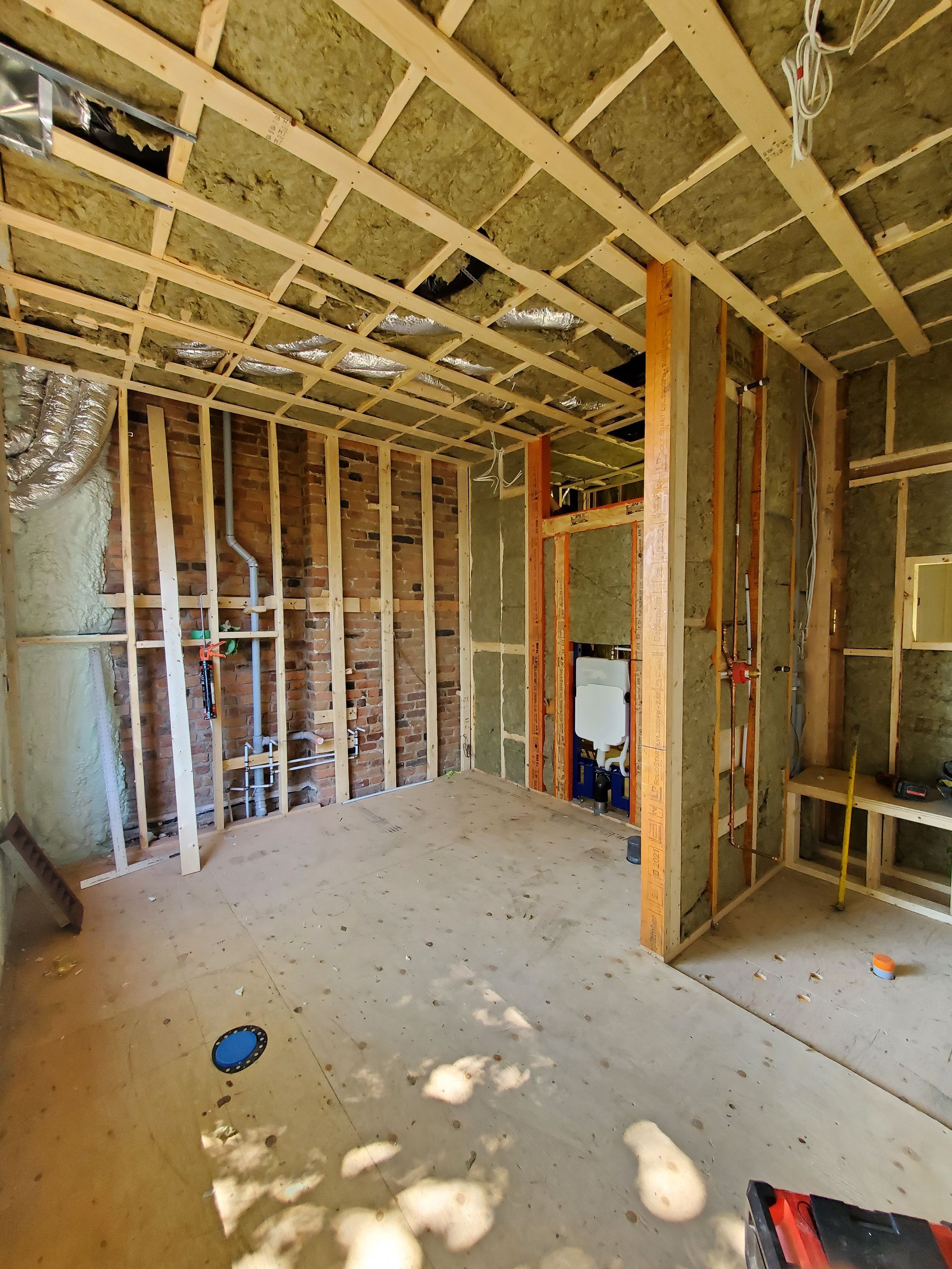 Une pièce avec un plafond en bois et des murs en briques en construction.