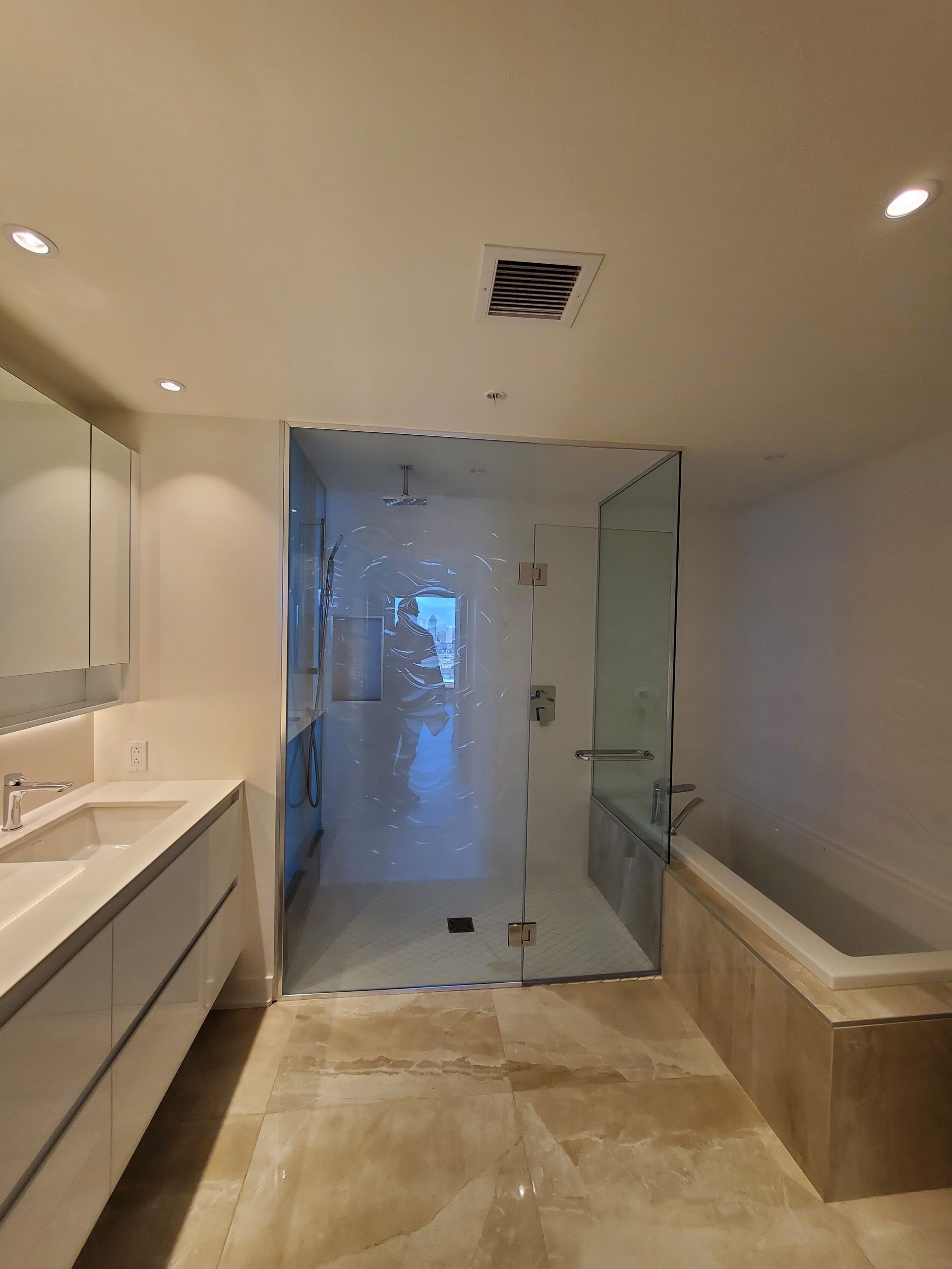 Une salle de bain avec douche à l'italienne, lavabo et baignoire.