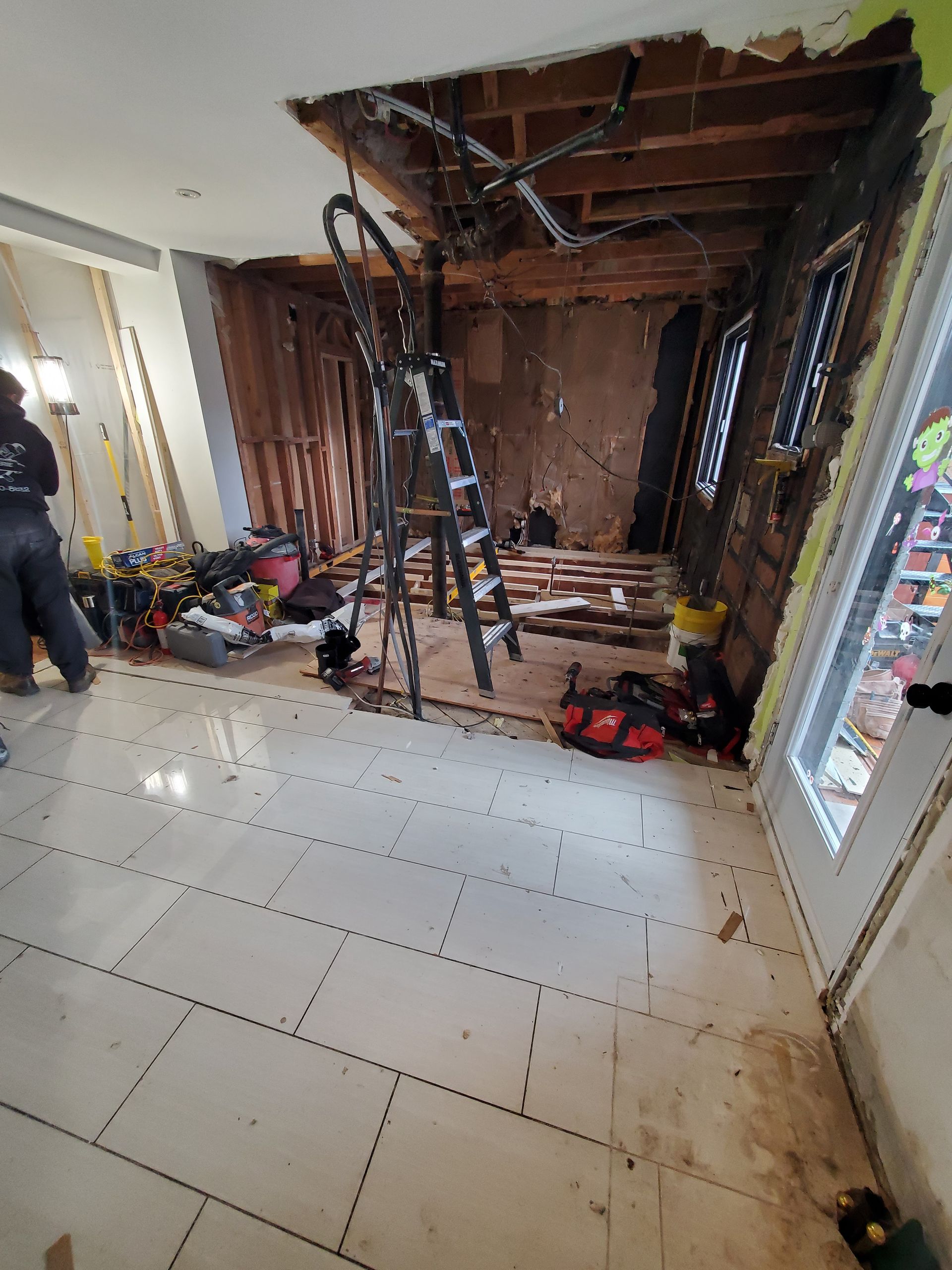 Une pièce en cours de rénovation avec une échelle suspendue au plafond.