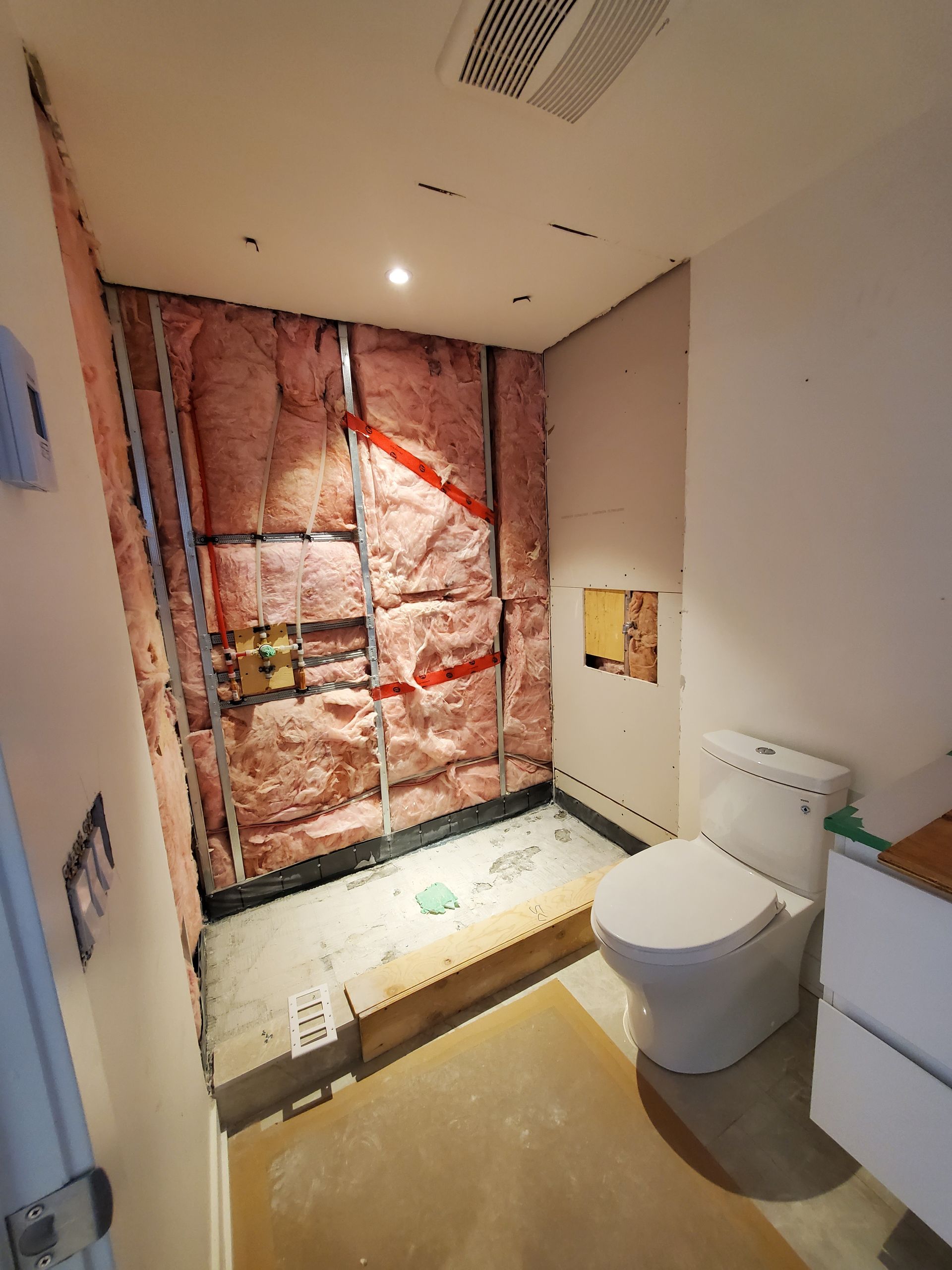 Une salle de bain avec WC et un mur recouvert d'isolation