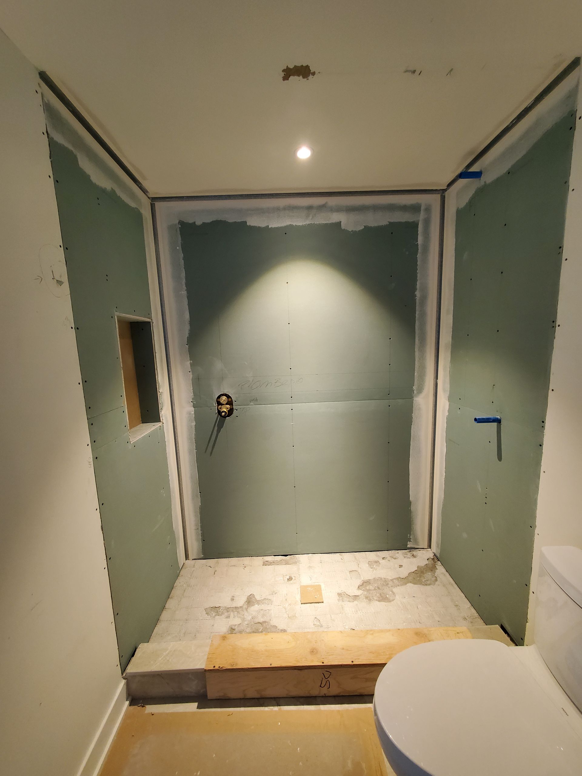 Une salle de bain en construction avec un WC et une porte