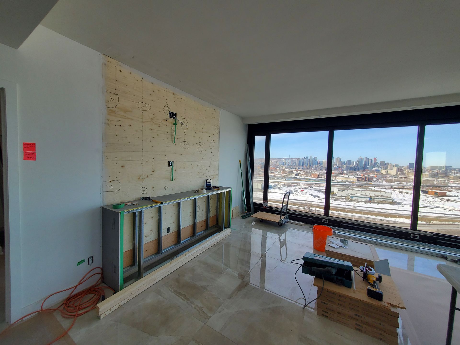 Un salon avec beaucoup de fenêtres et un mur en bois.