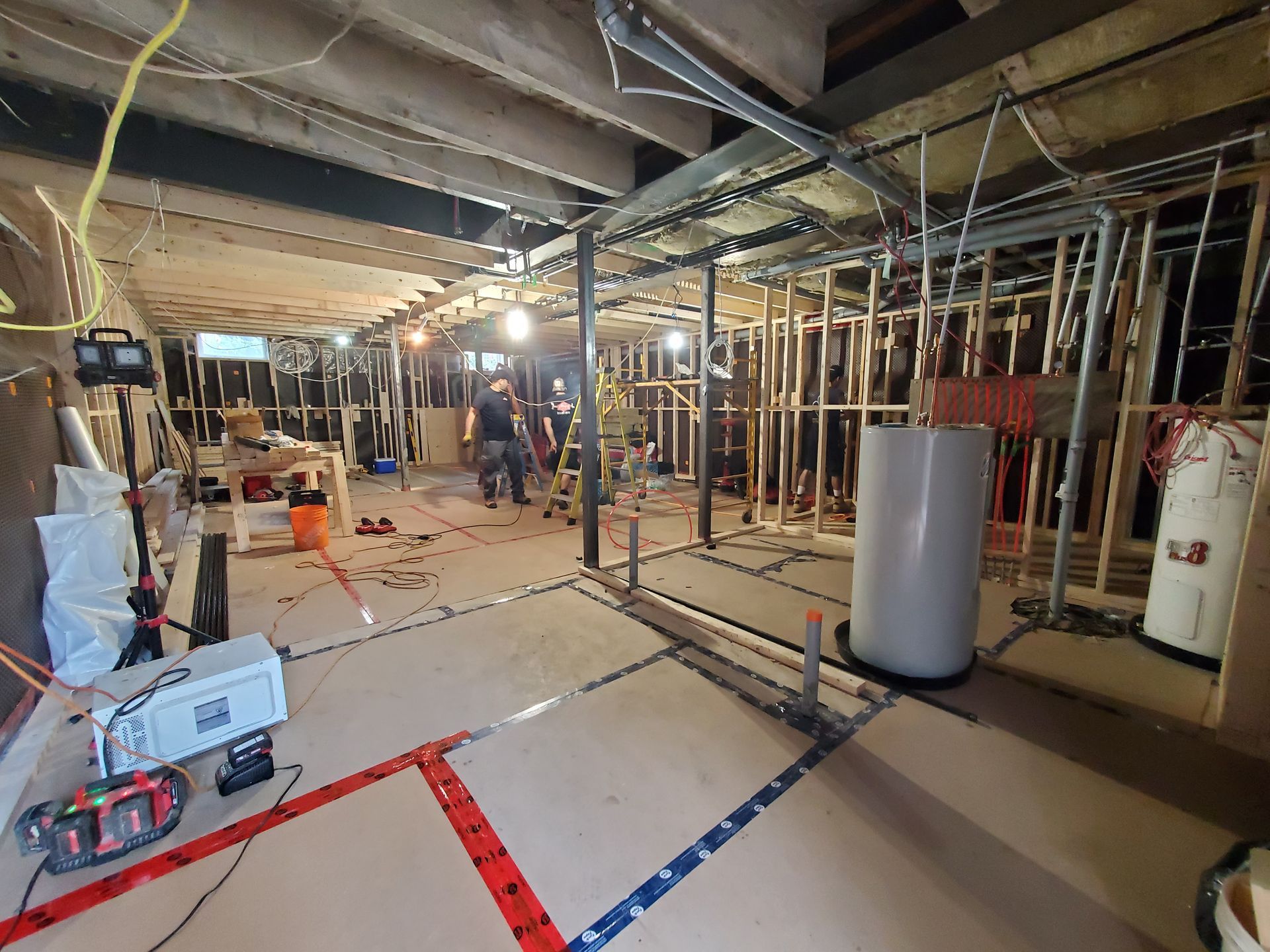 Un sous-sol en construction avec beaucoup de fils suspendus au plafond.