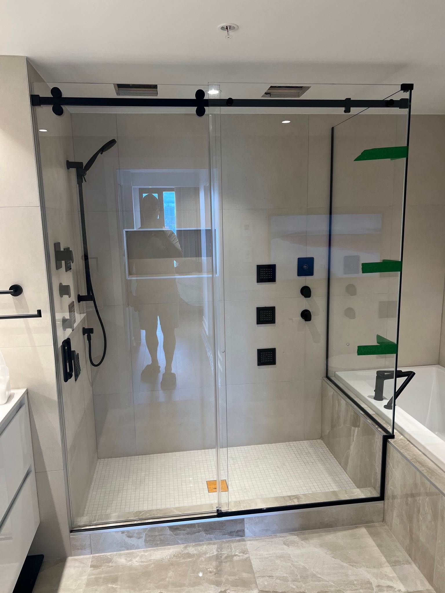 Une salle de bain avec une porte de douche coulissante en verre et une baignoire.