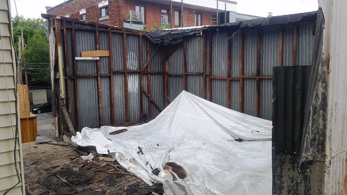 Une bâche blanche est posée devant un bâtiment en cours de démolition.