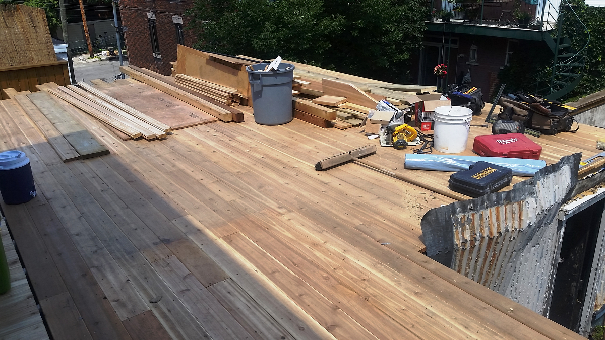 Une terrasse en bois est en cours de construction au sommet d'un bâtiment.