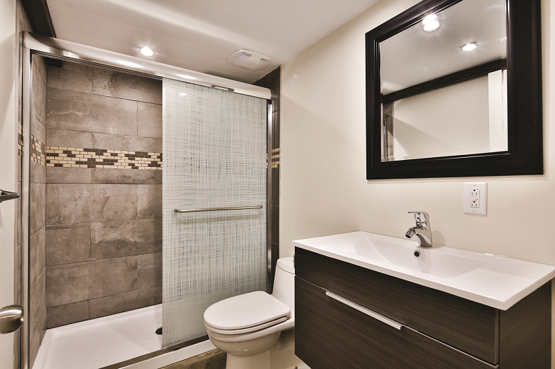Une salle de bain avec WC, lavabo, douche et miroir