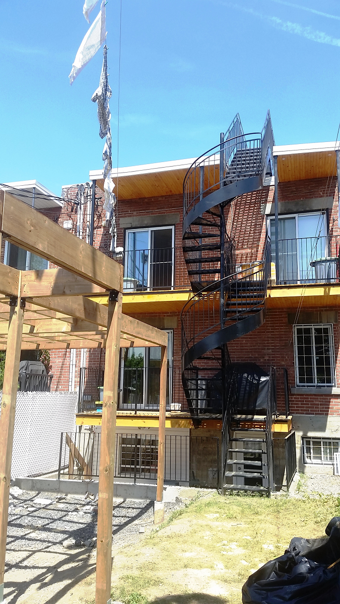 Un bâtiment en brique avec un escalier en colimaçon sur le côté.