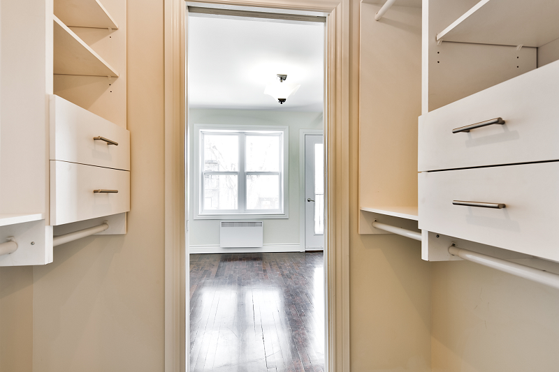 Un dressing avec beaucoup d'étagères et de tiroirs