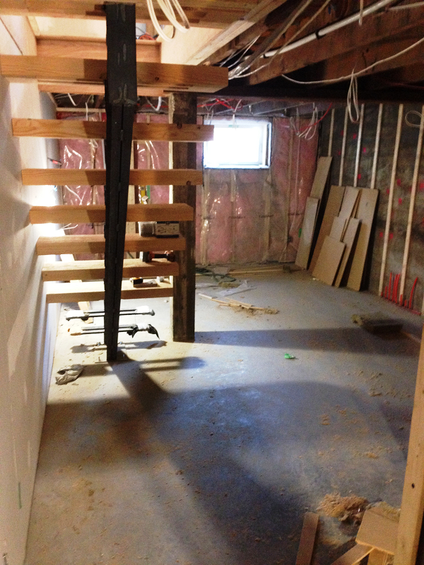 Une pièce vide avec un escalier en bois et une fenêtre