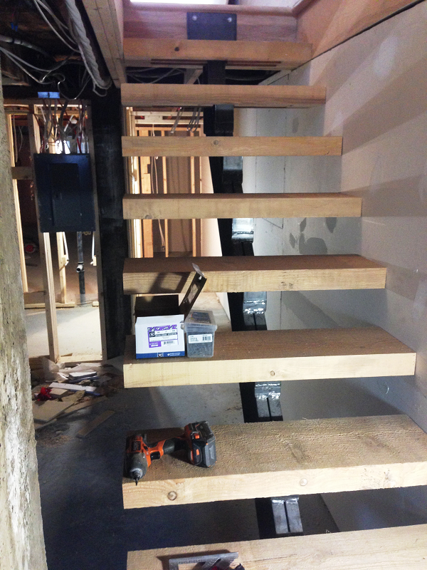 Un escalier en bois est en cours de construction dans une maison