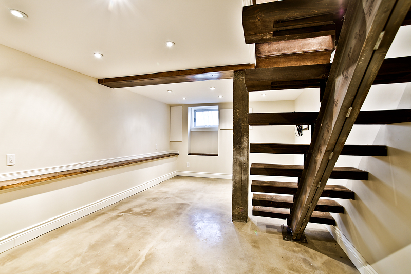 Une pièce vide avec un escalier en bois menant au deuxième étage.