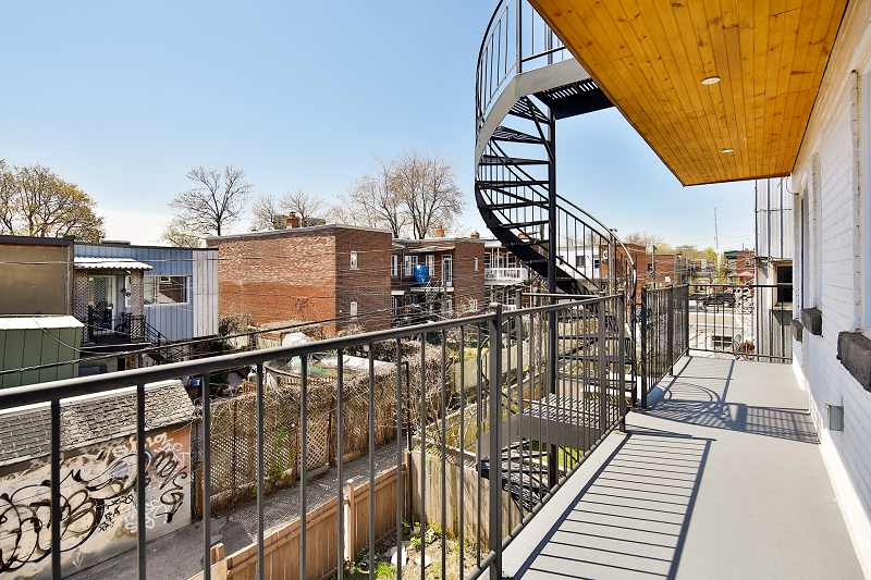 Un balcon avec un escalier en colimaçon qui y mène