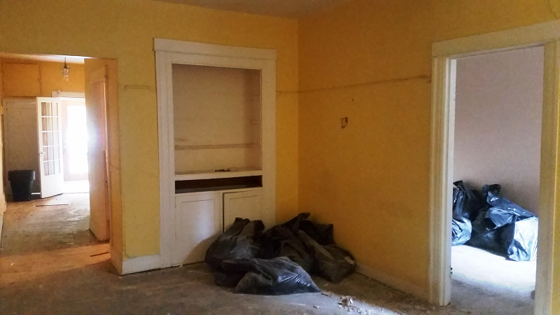 Une pièce avec des murs jaunes et des sacs noirs au sol.