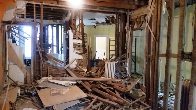 Une maison est en train d'être démolie et il y a beaucoup de bois dans la pièce.
