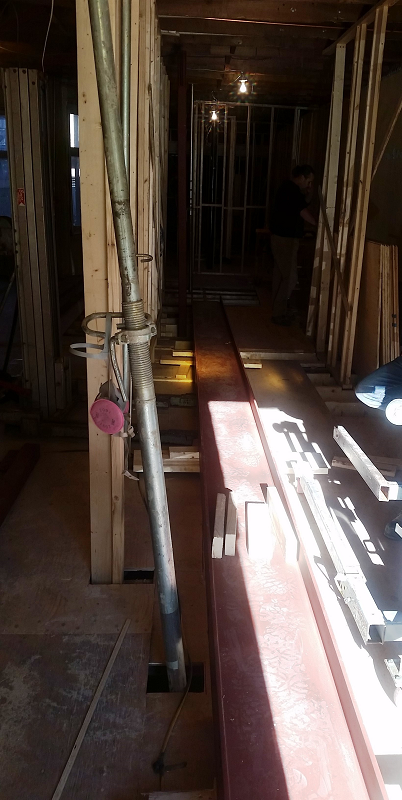 Un poteau d'échafaudage est suspendu au plafond d'un bâtiment en construction.