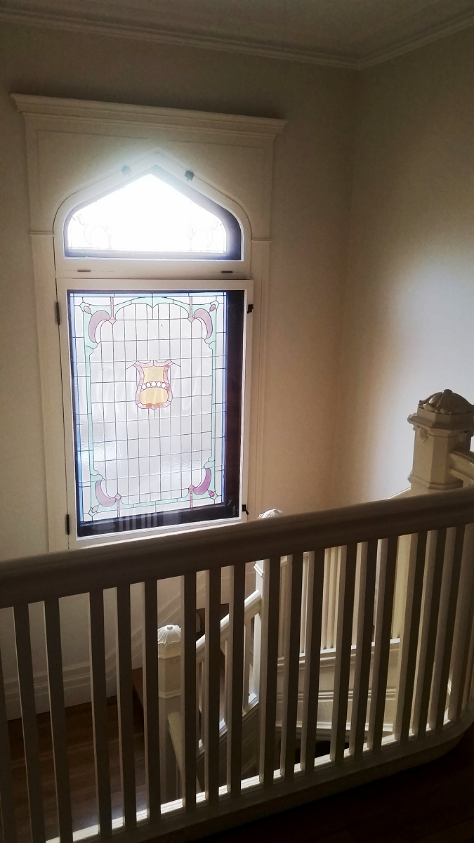 Un escalier avec un vitrail et une rampe.