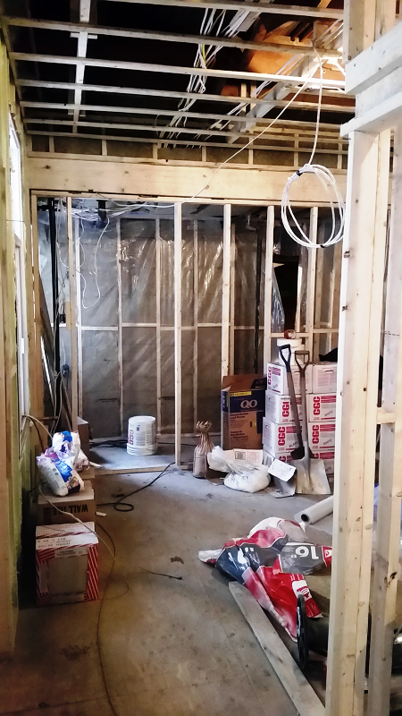 Une pièce en construction avec beaucoup de cartons et d'outils au sol.