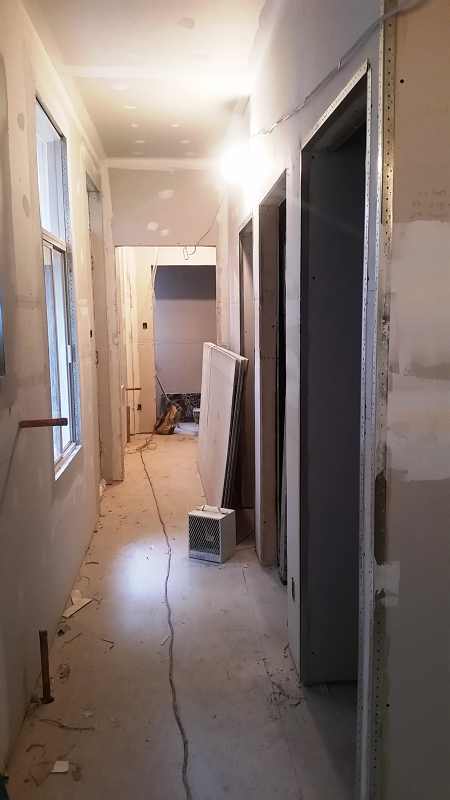 Un long couloir avec beaucoup de portes et fenêtres en construction.